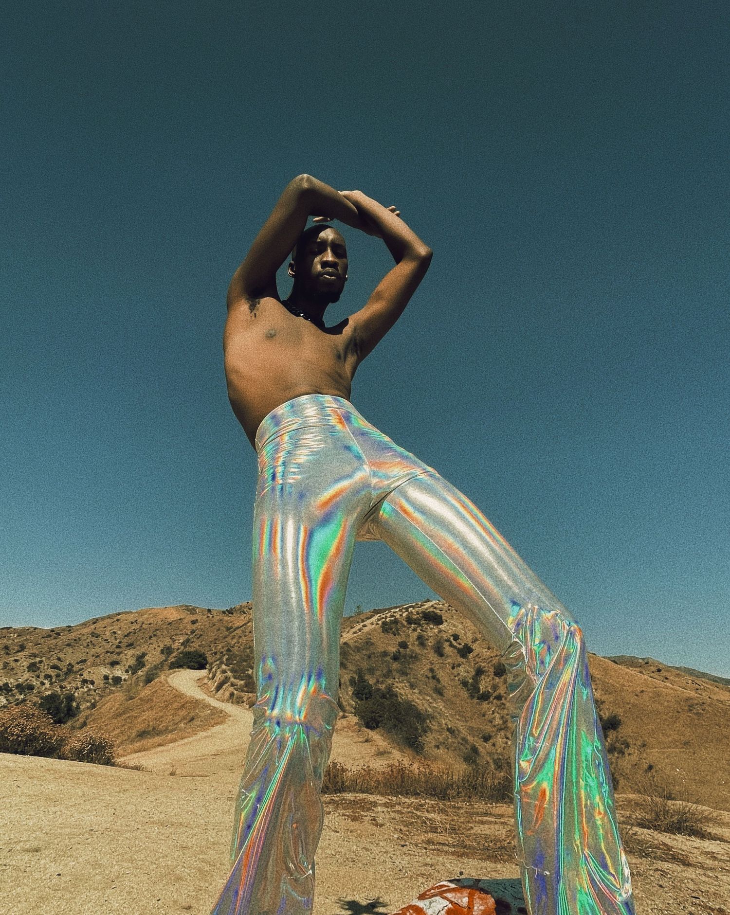 Figure in iridescent dress poses dramatically against desert landscape with mountains in background. PZ STUDIO VISUALS  x Beoncia Dunn