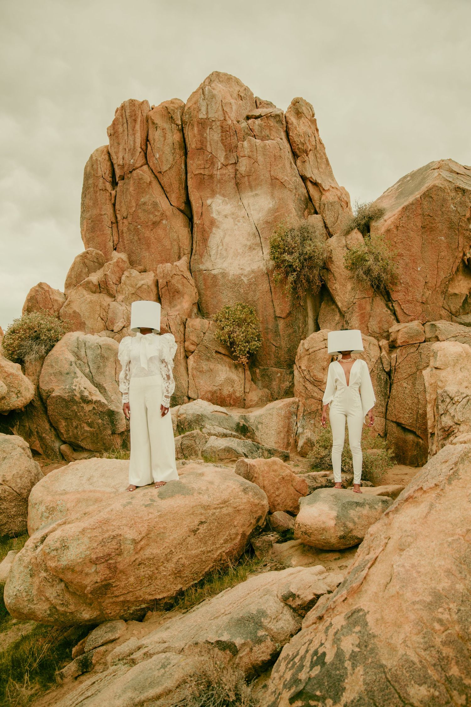 White sculptural figures positioned along desert rock formations. PZ STUDIO VISUALS