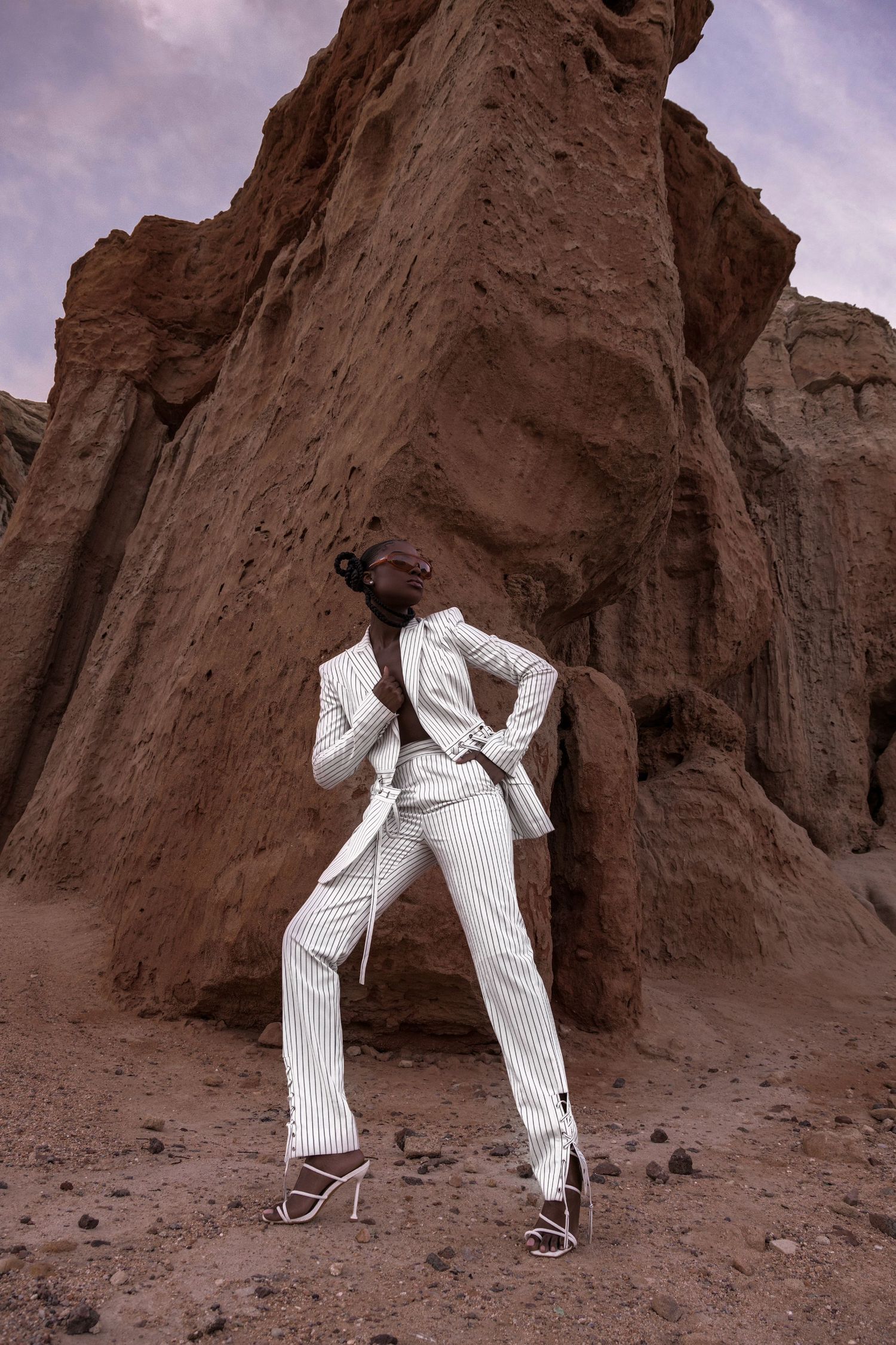 White pinstriped pants and heels photographed against rocky desert landscape. PZ STUDIO VISUALS