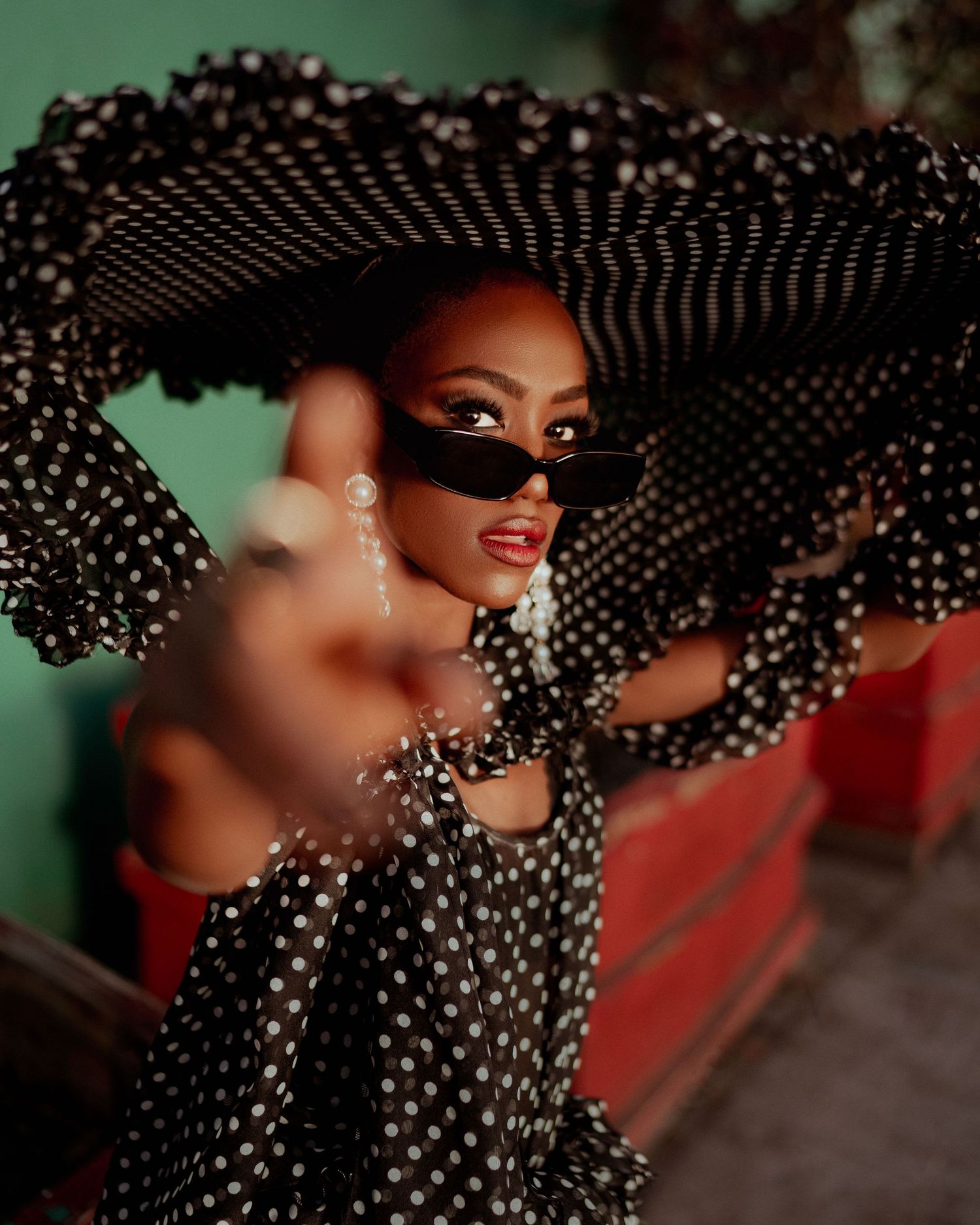 Glamorous fashion photo with polka dot hat and dramatic lighting against dark background. PZ STUDIO VISUALS