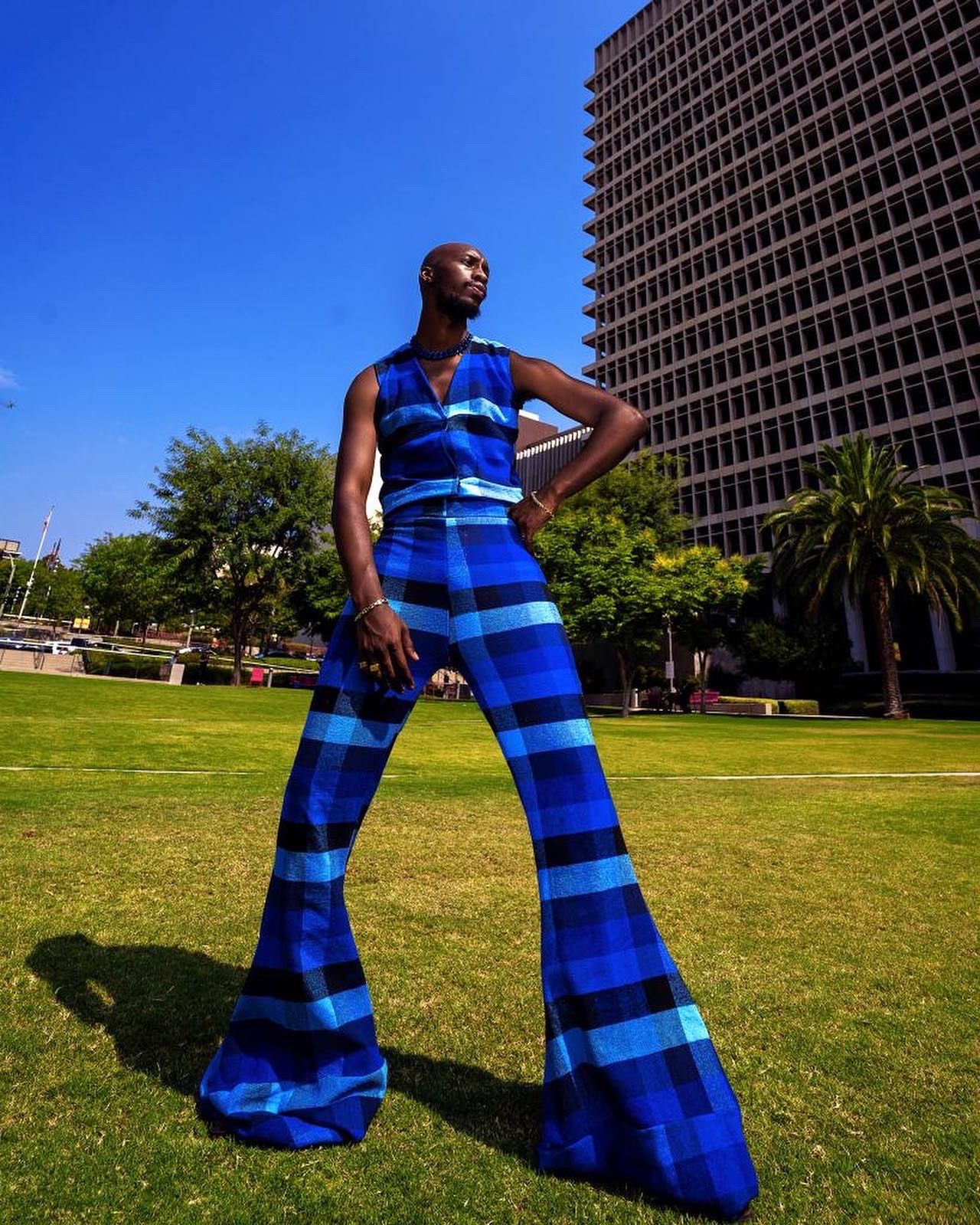 Dynamic poses in a bright blue striped dress on a sunny lawn with modern architecture. Features Kalema Jon PZ STUDIO VISUALS