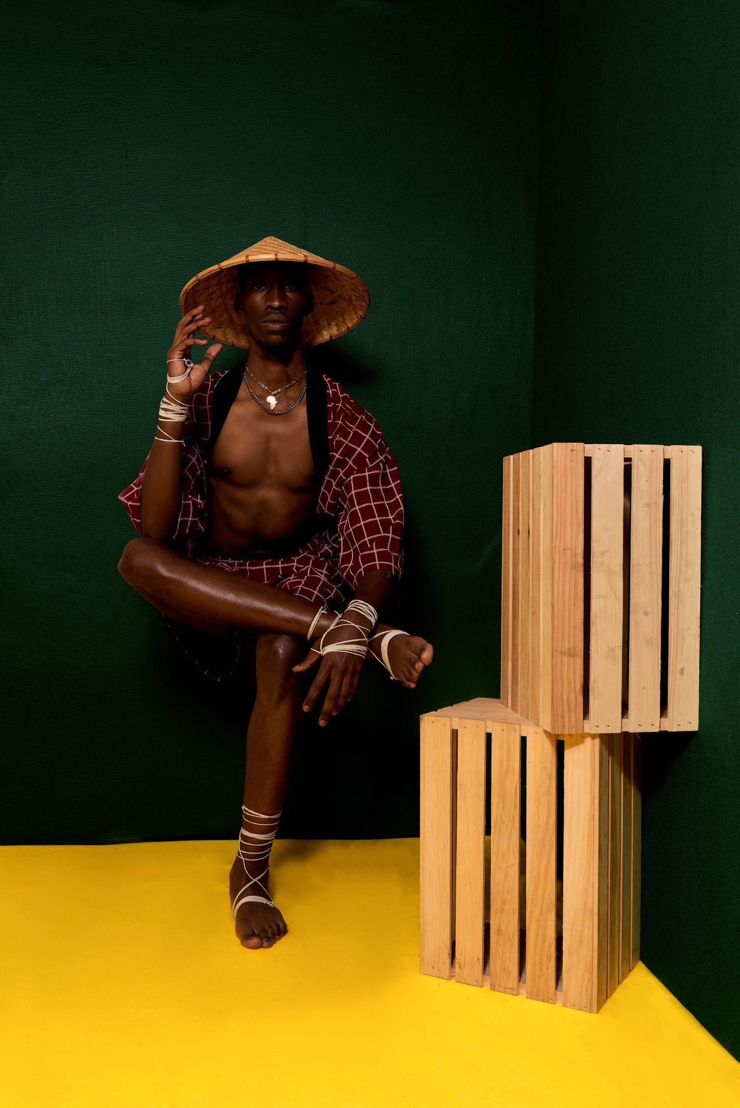 Studio portrait with wooden crates against dark green and yellow background.PZ STUDIO VISUALS