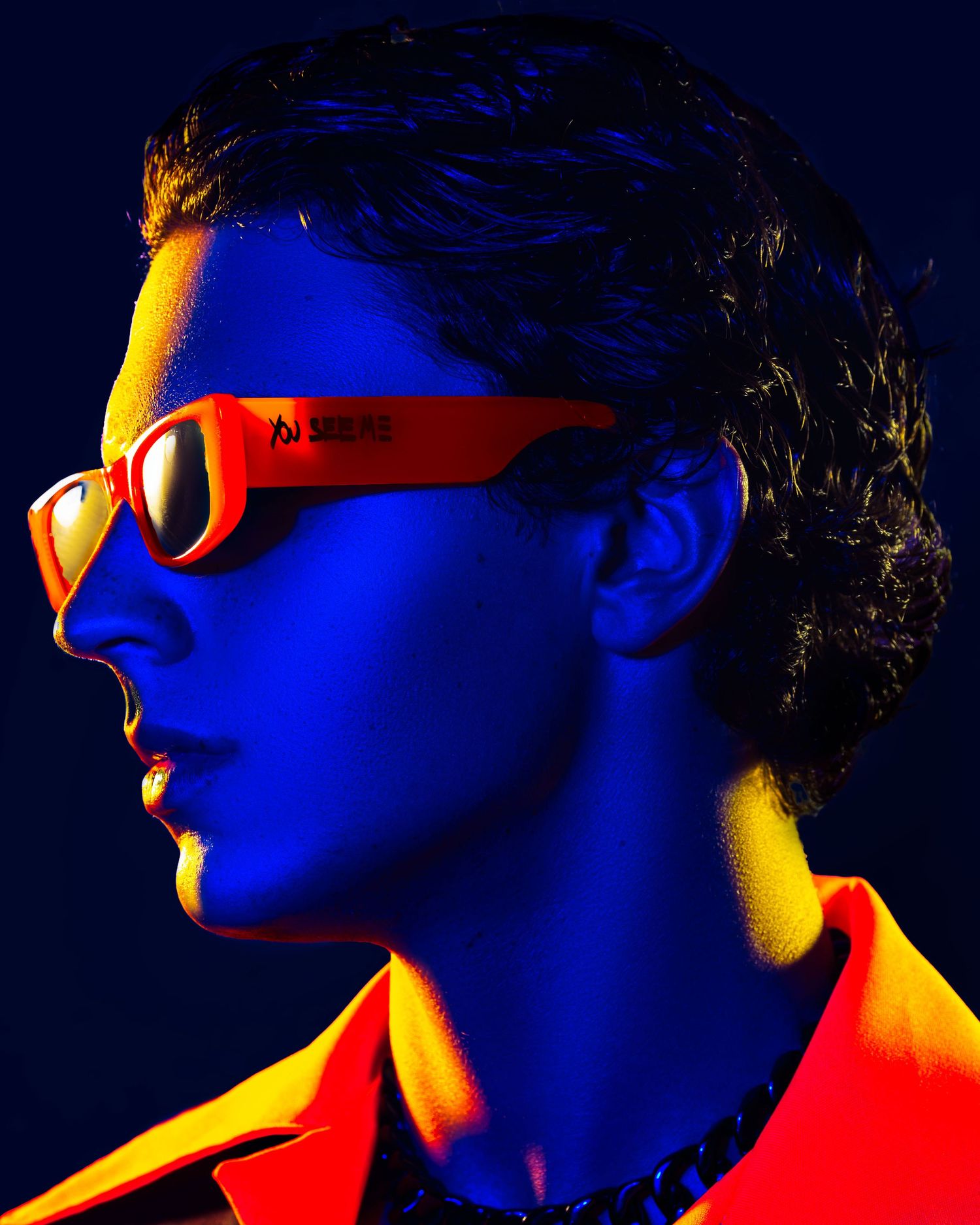 Dramatic profile portrait with red sunglasses in blue and yellow lighting. PZ STUDIO VISUALS