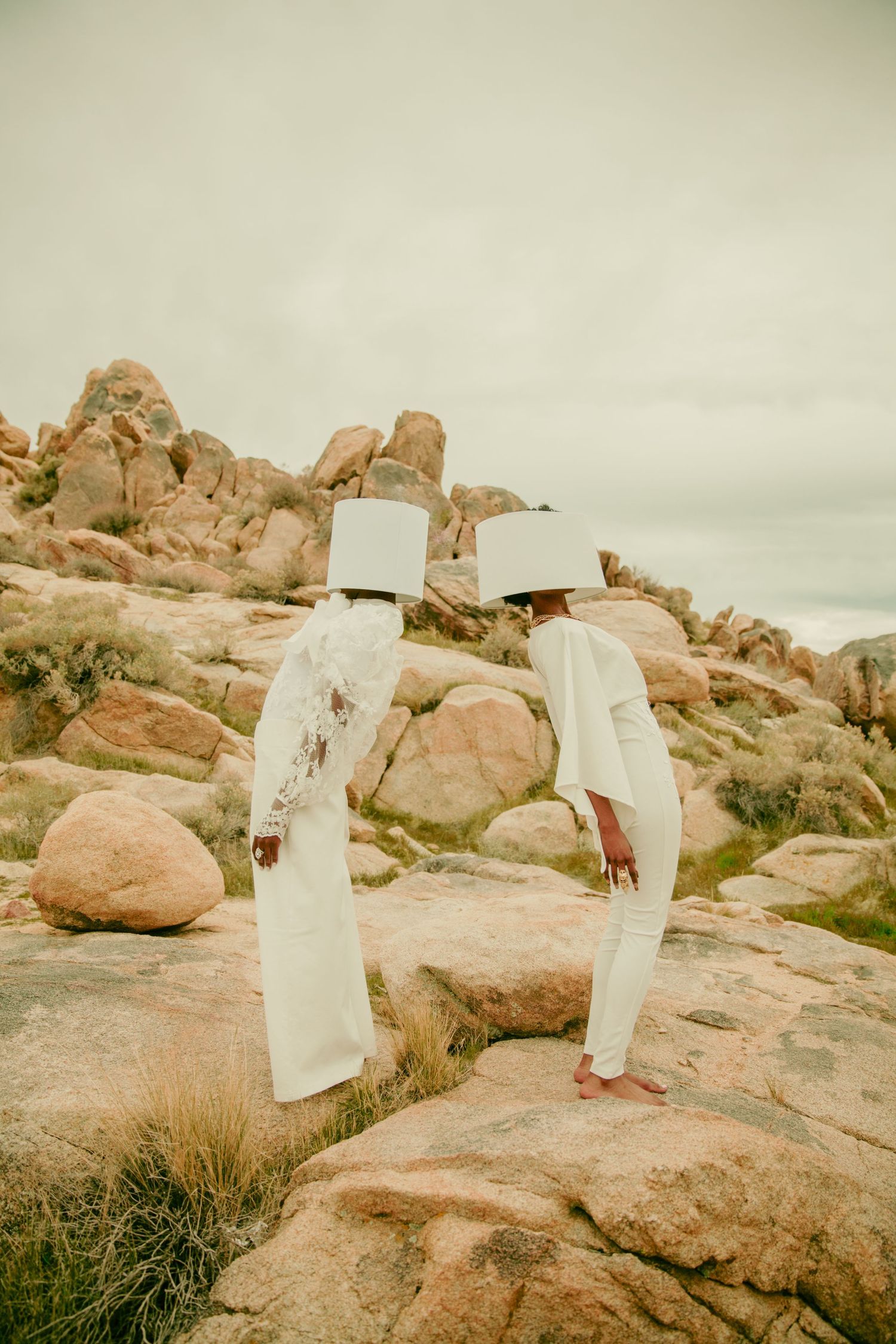 White fabric installations arranged on desert rocks under an overcast sky. PZ STUDIO VISUALS