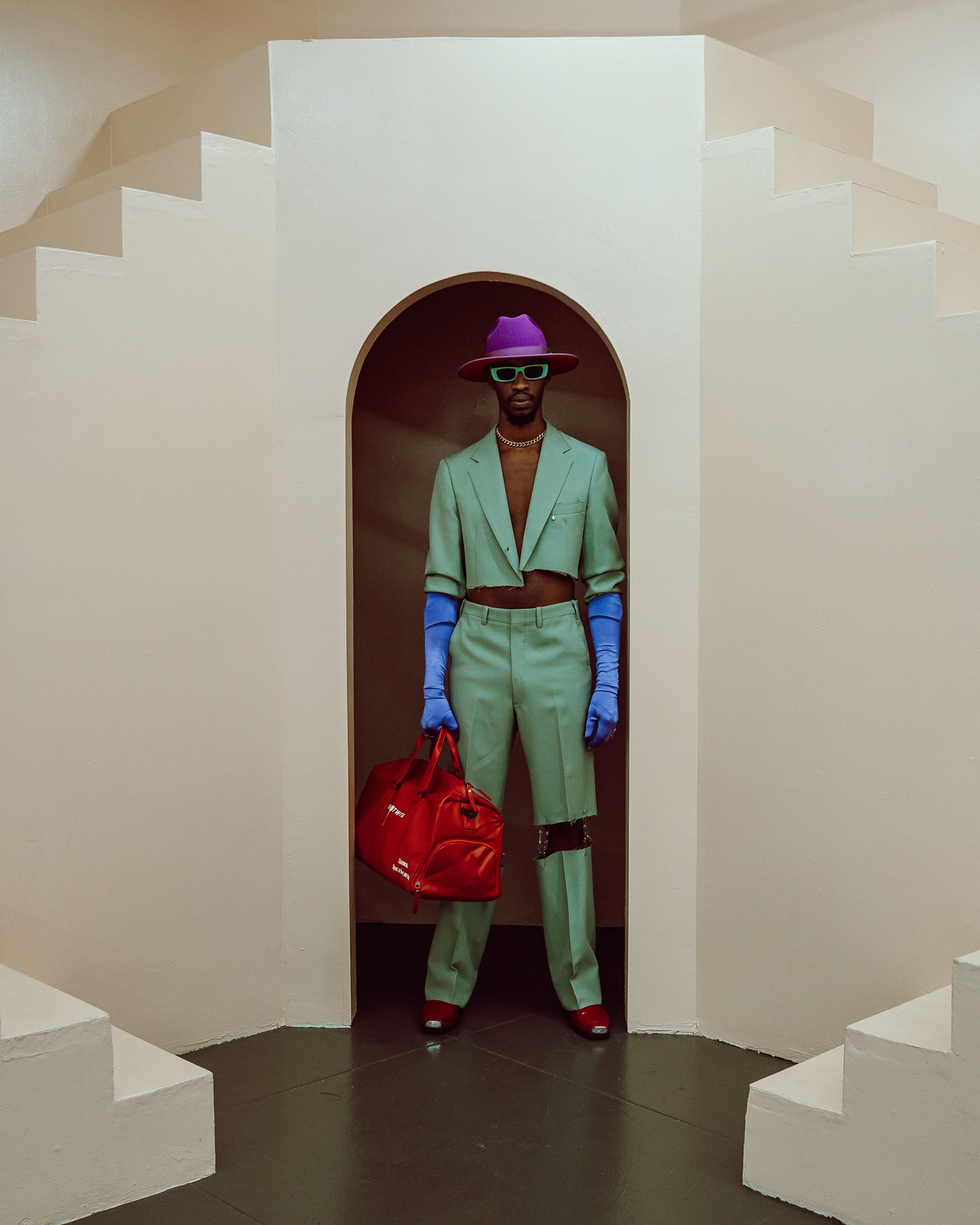 Stylish mint green suit with purple hat and red bag framed in white architectural doorway. PZ STUDIO VISUALS