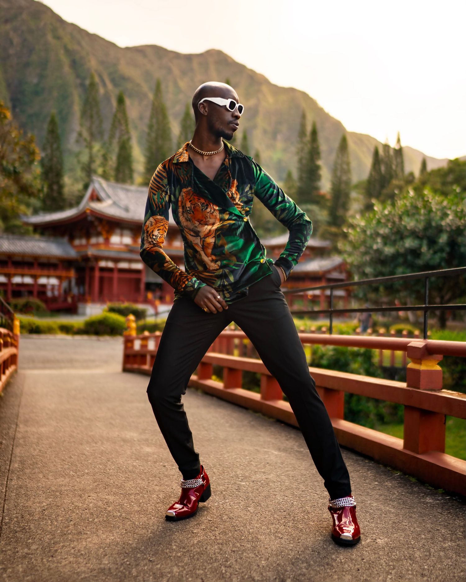 Dynamic pose in patterned jacket and sunglasses with Asian temple backdrop. PZ STUDIO VISUALS  in Honalulu Hawaii