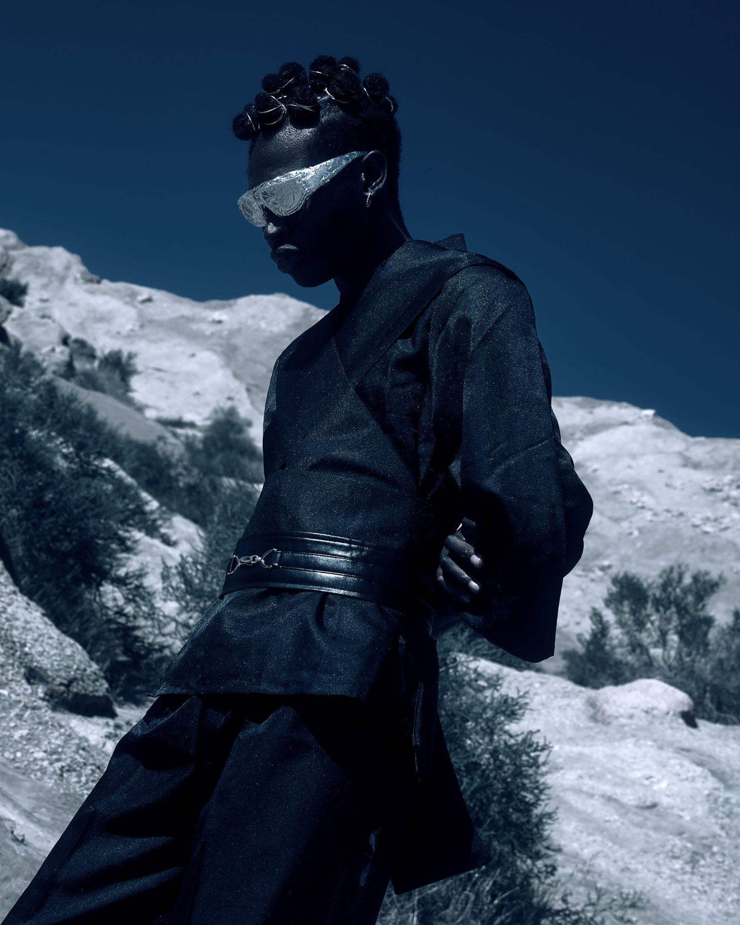Dramatic fashion portrait in dark clothing against snowy mountain backdrop. PZ STUDIO VISUALS