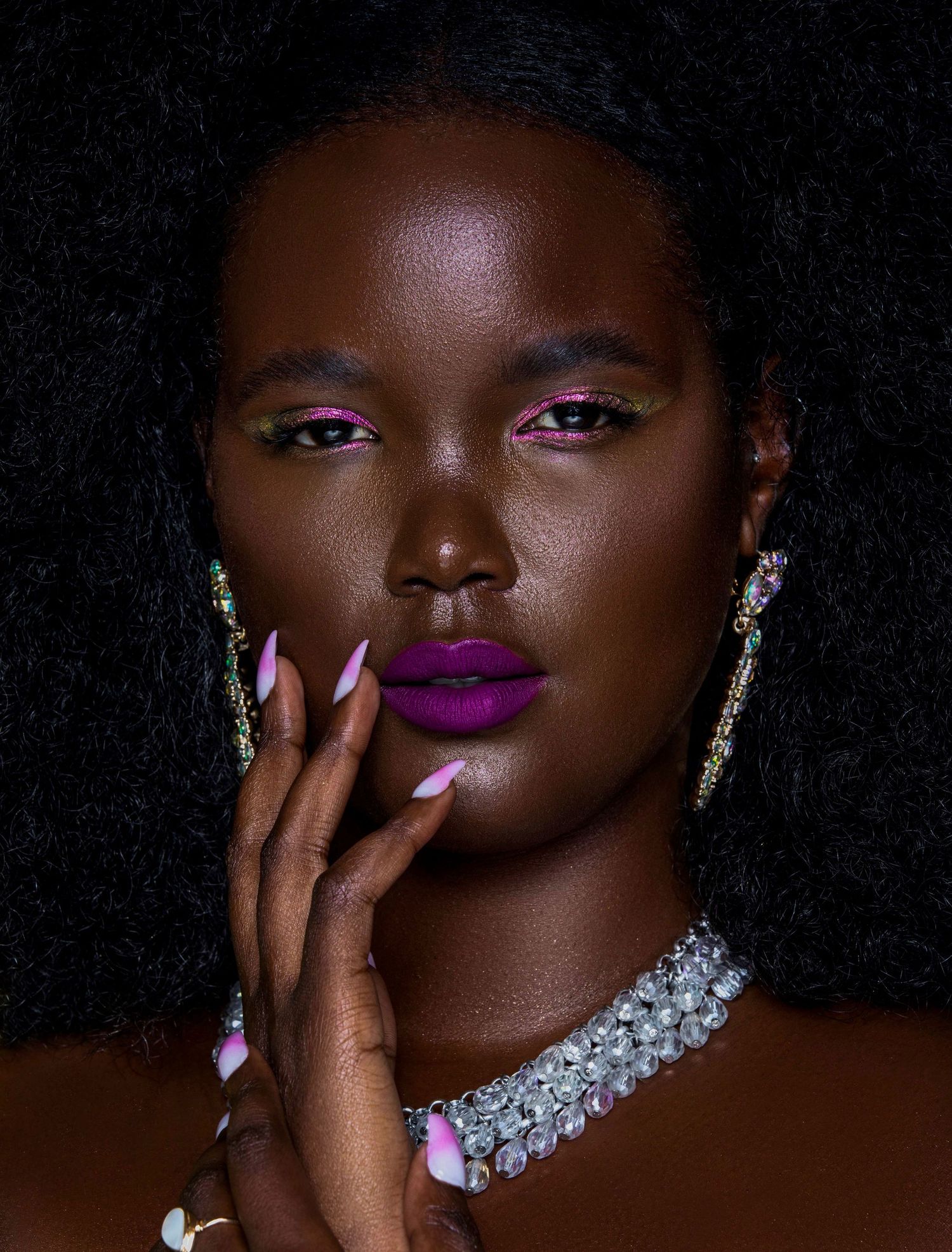 Close-up beauty shots featuring bold purple lipstick, glittering jewelry and dramatic makeup against a dark background. PZ STUDIO VISUALS