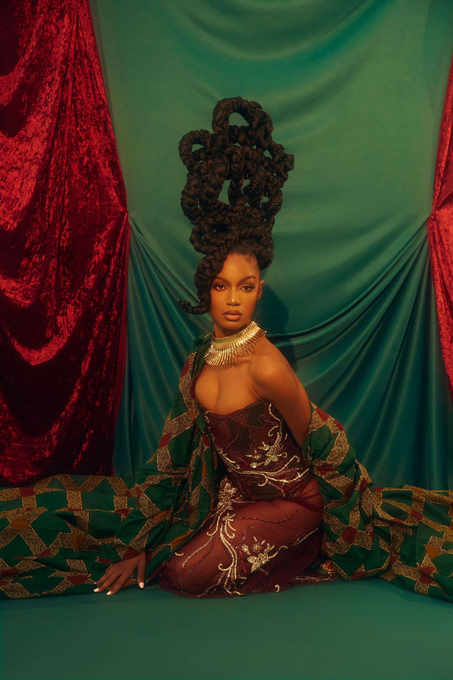 A dramatic portrait against green and red velvet drapes with ornate styling and jewelry. Ebonee Davis photo by Jacob Webster PZ STUDIO VISUA