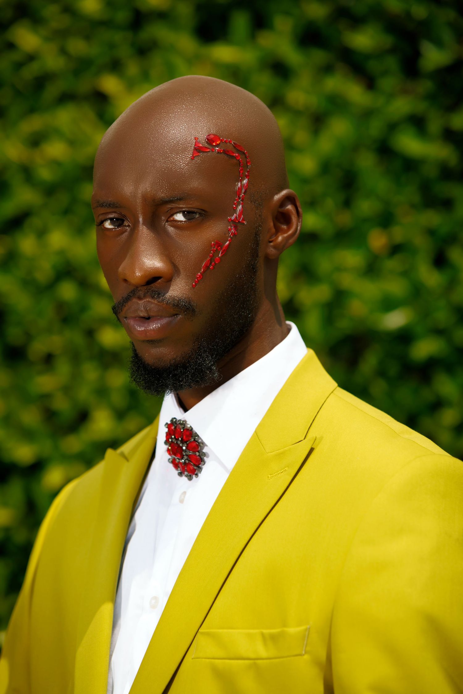 Portrait in bright yellow suit with red facial art and floral brooch. PZ STUDIO VISUALS x Beoncia Dunn