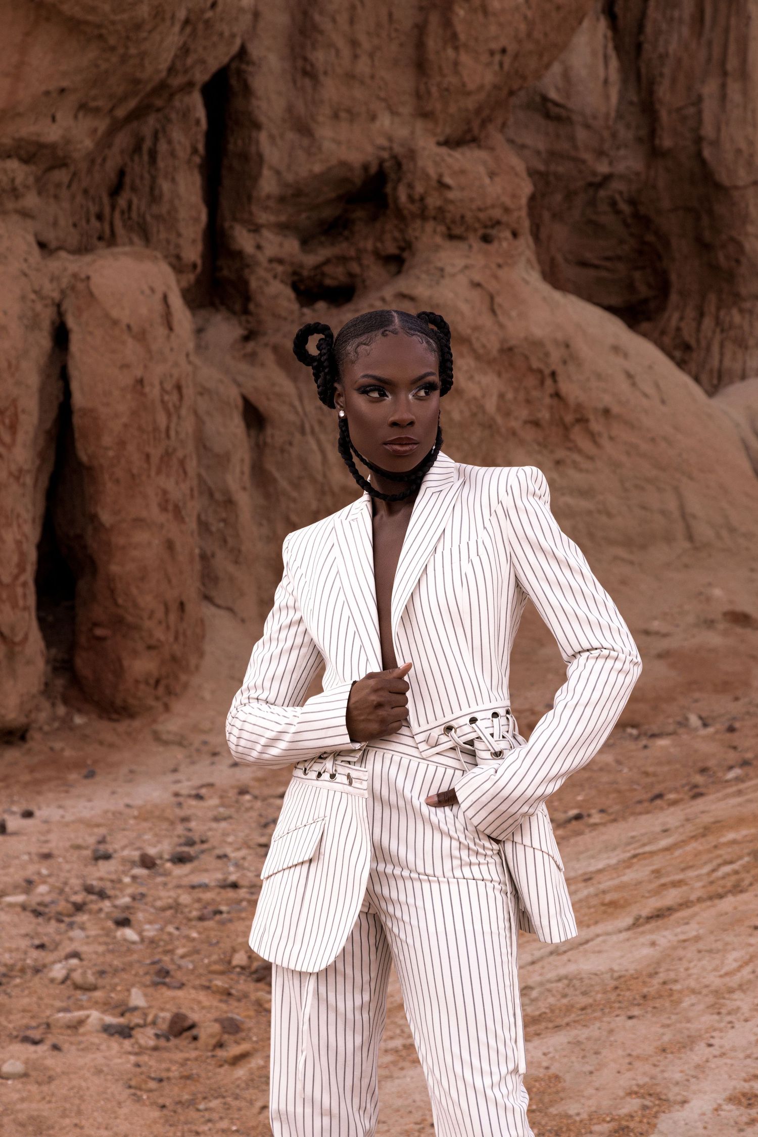 Fashion editorial featuring white pinstriped suit against desert rock formations. PZ STUDIO VISUALS
