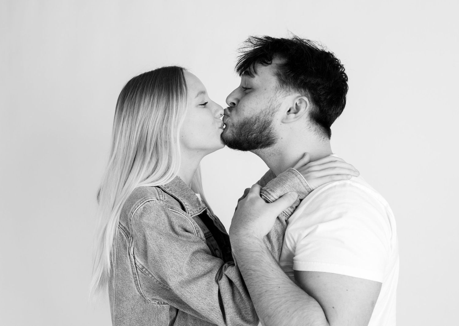 Romantic couple sharing intimate moment against white background.