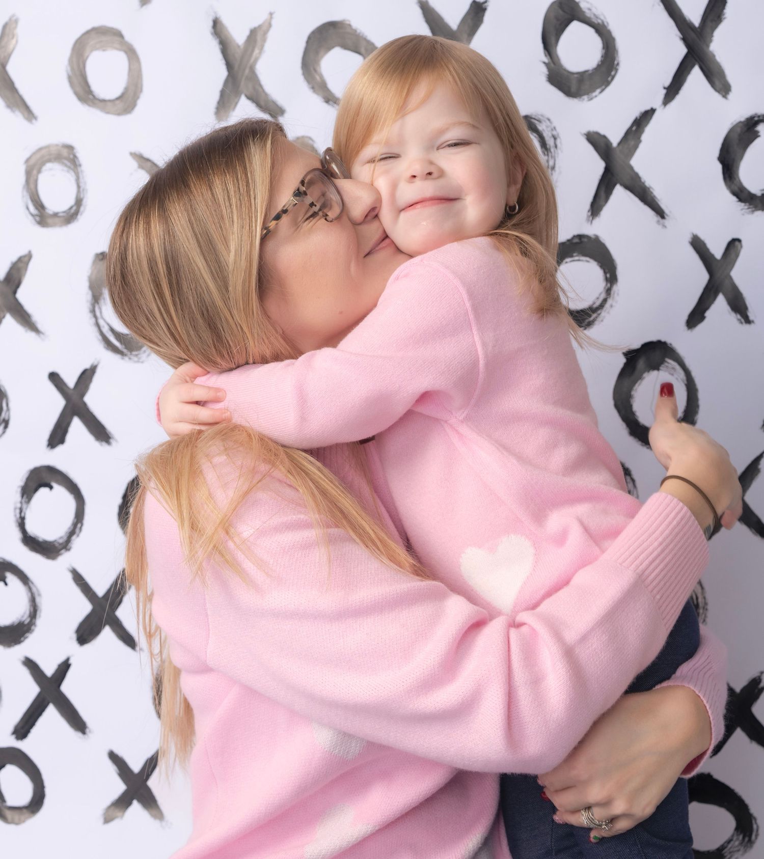 Lifestyle photos against XO pattern backdrop in soft pink tones.