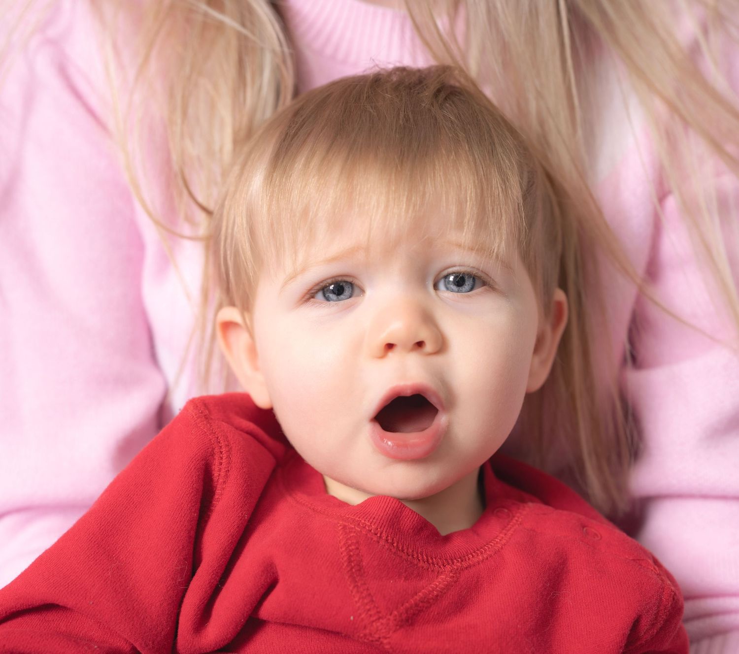 Series of photos showing child in red sweater on pink background.