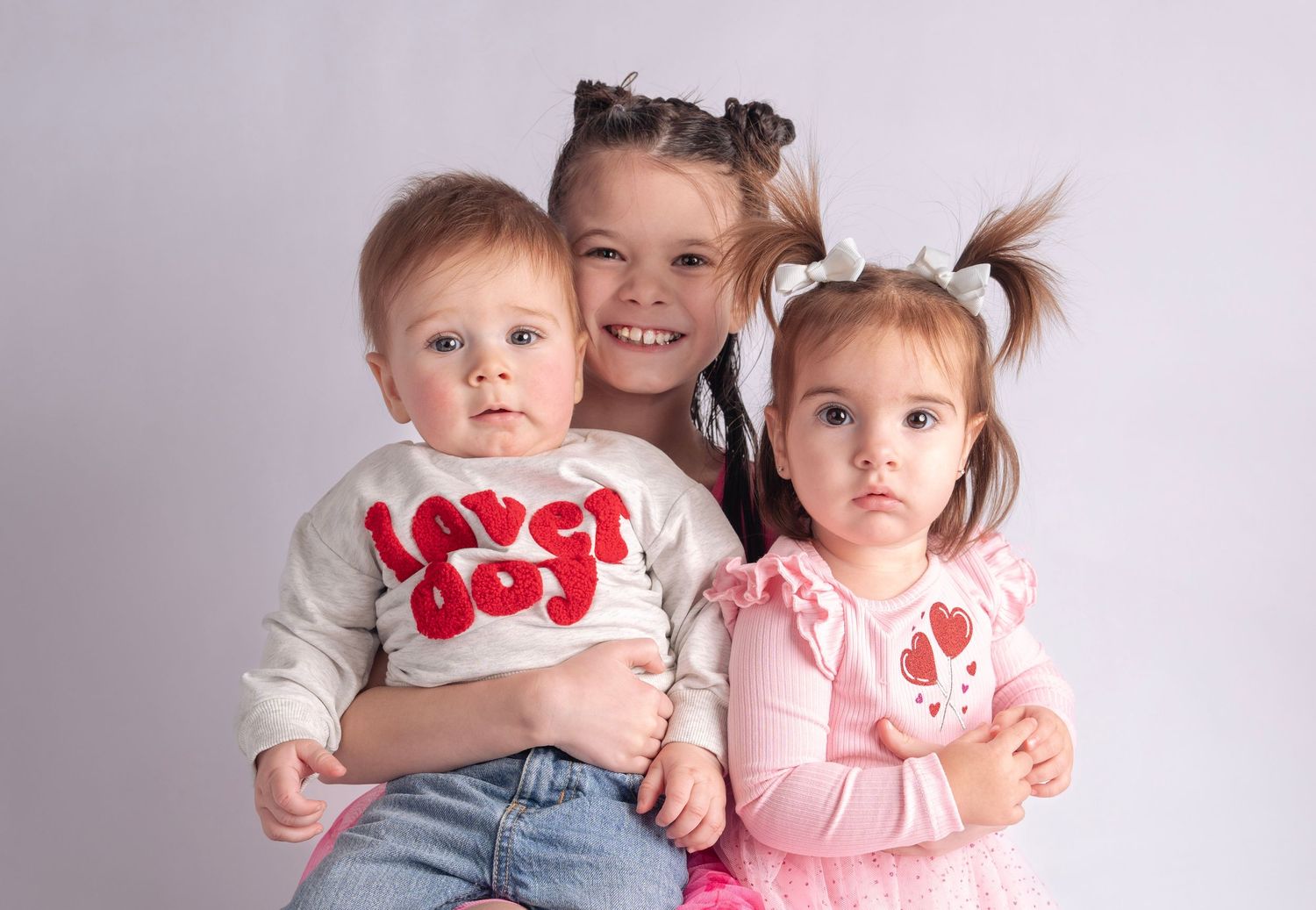 Sweet family portrait series against white background featuring matching Valentine's Day themed outfits.