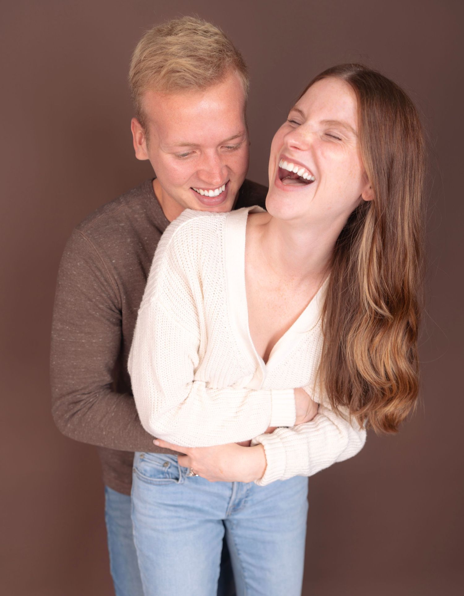 A candid moment of genuine laughter between a couple in casual attire.