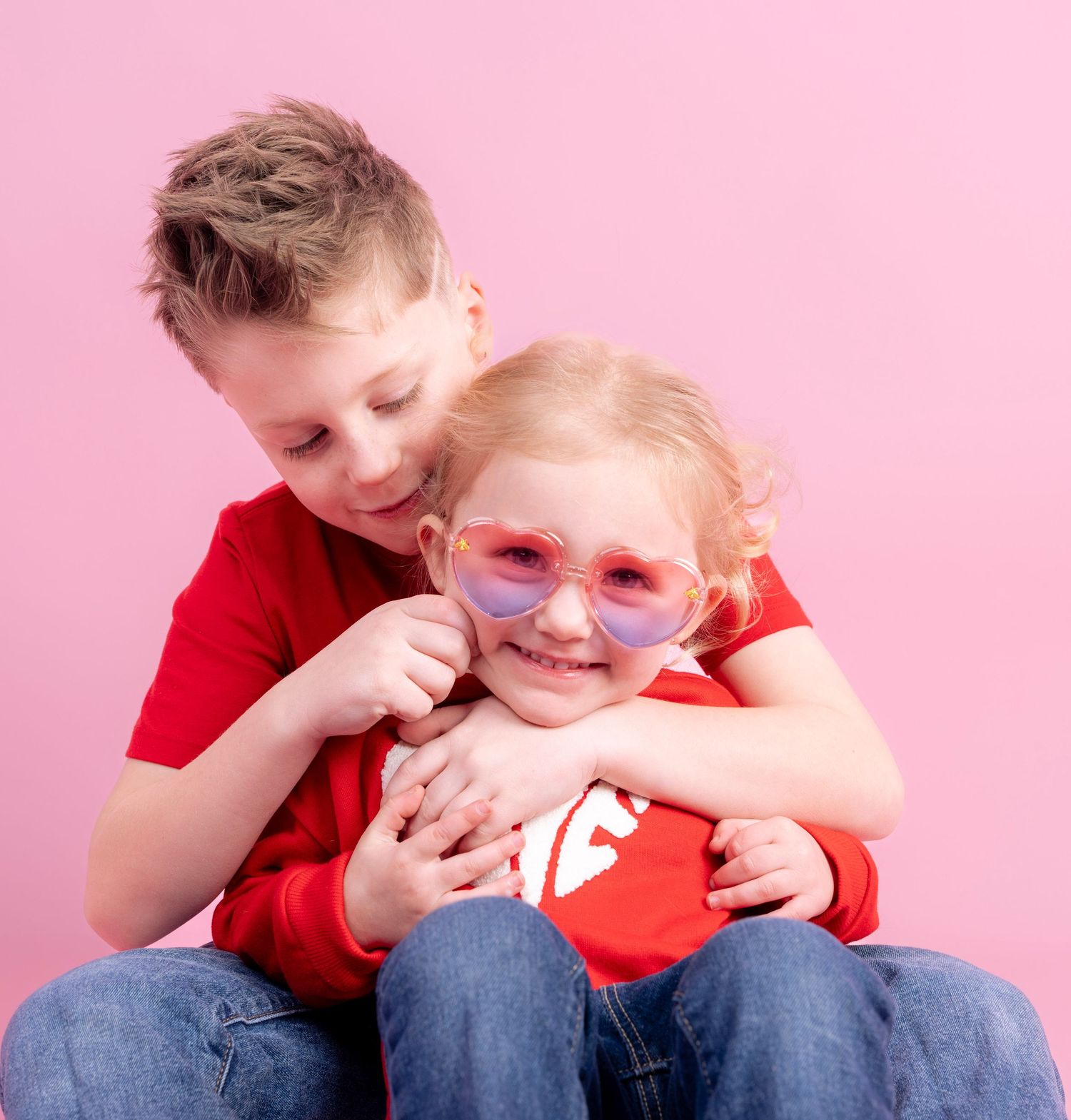 Series of candid playful moments wearing red shirt and glasses against pink backdrop.
