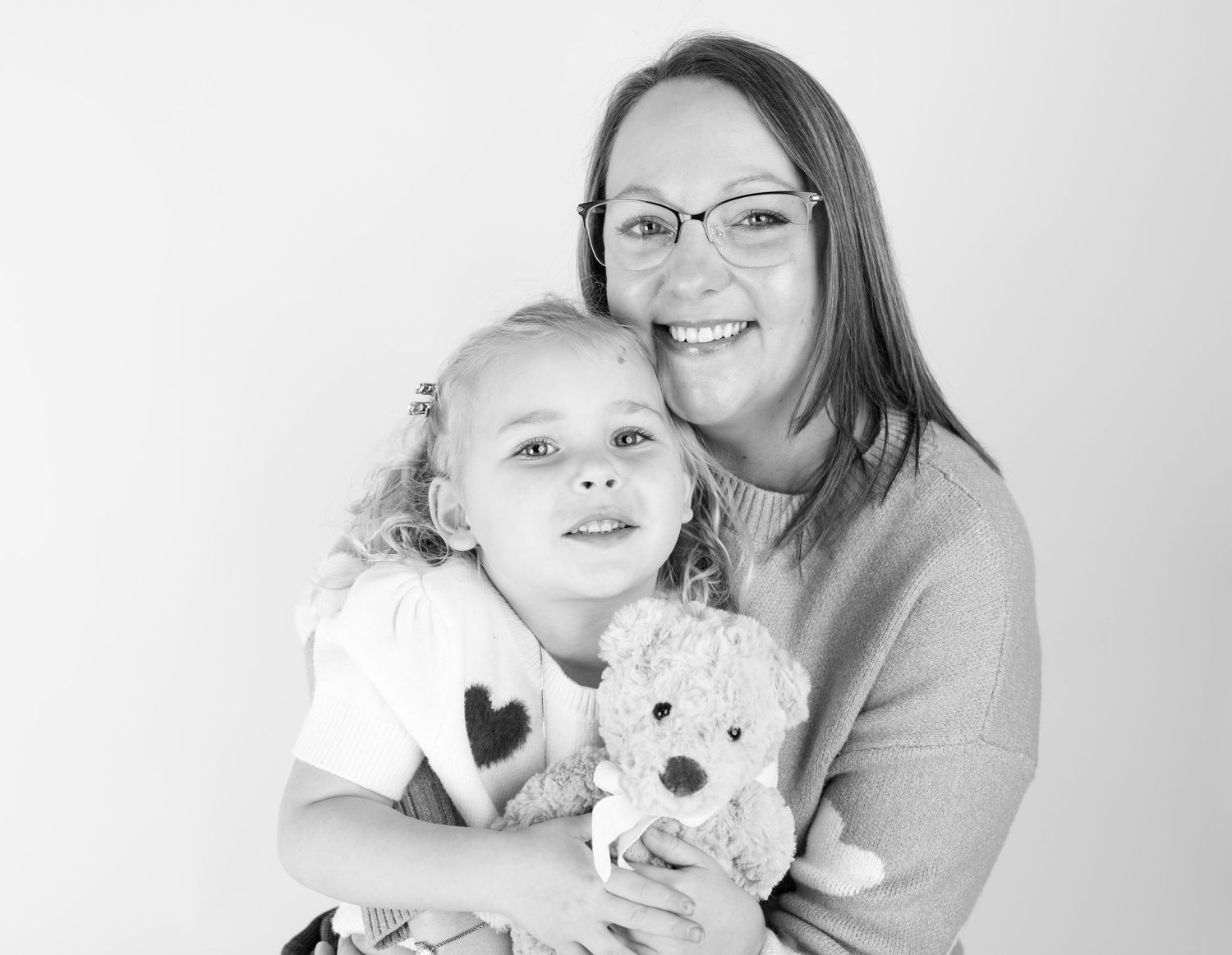 Black and white family portrait series showing tender moments and embraces.