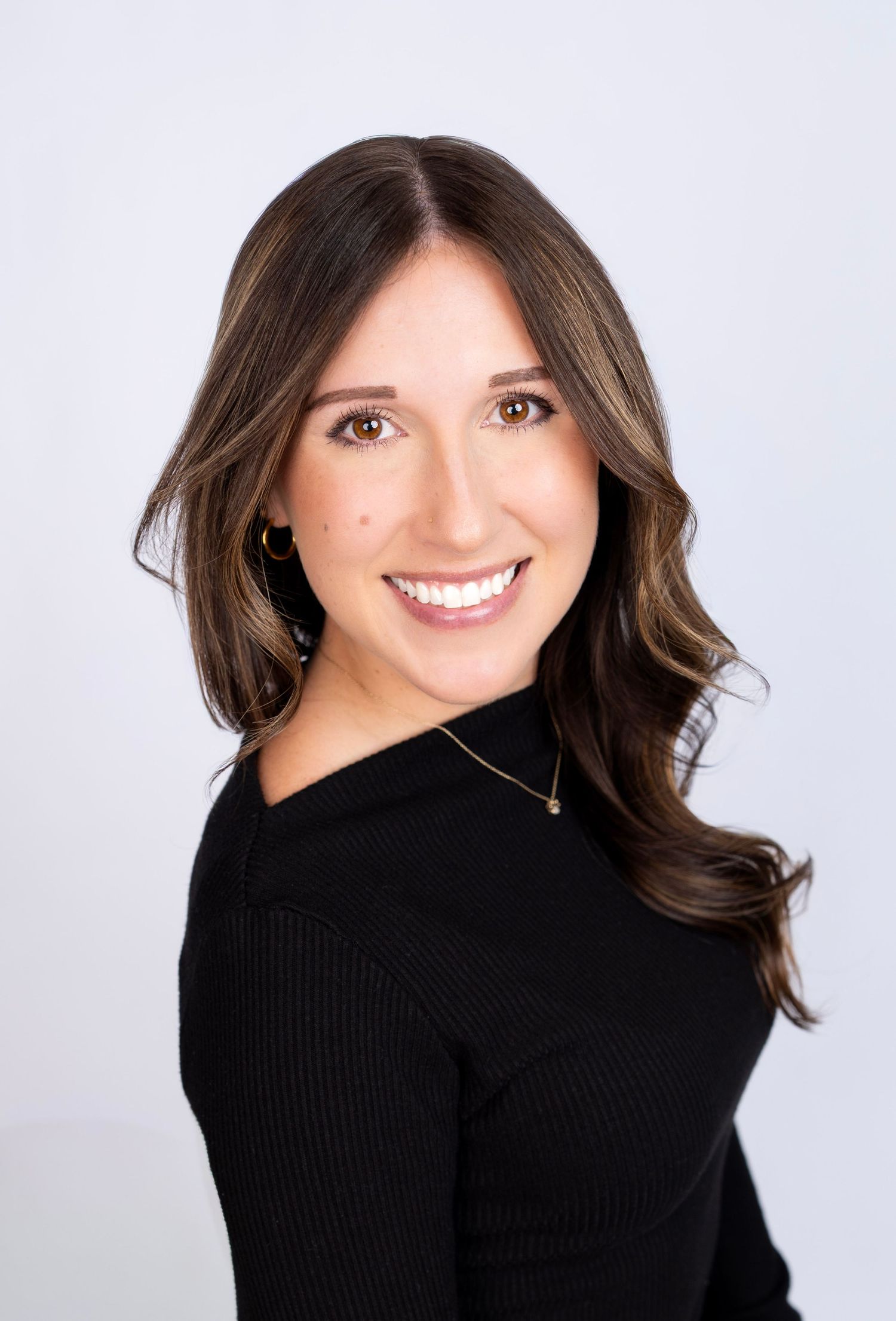 Studio portraits featuring black turtleneck sweater with natural makeup and styled hair.