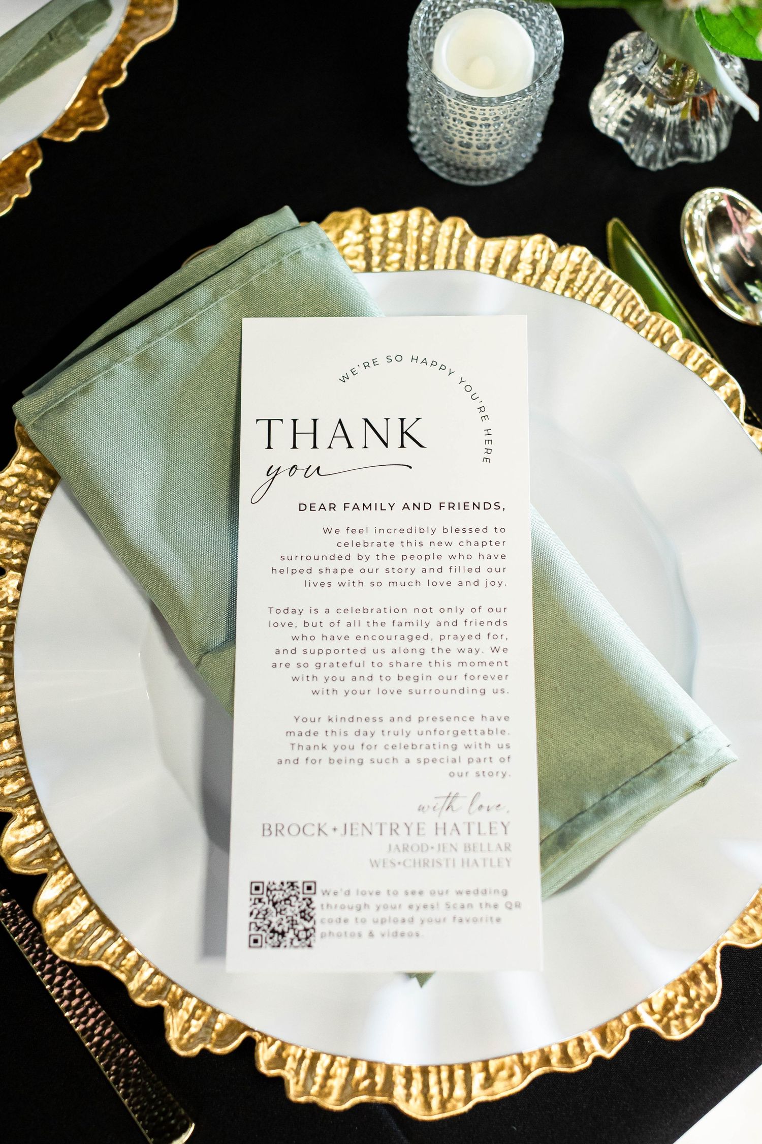 Elegant table settings with gold charger plates, white napkins, and thank you notes featuring QR codes at a formal event.