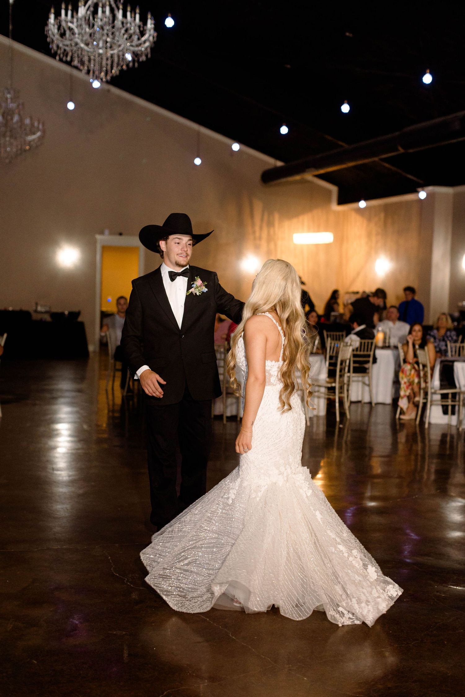 Romantic dance sequence of newlyweds in a spacious ballroom setting.