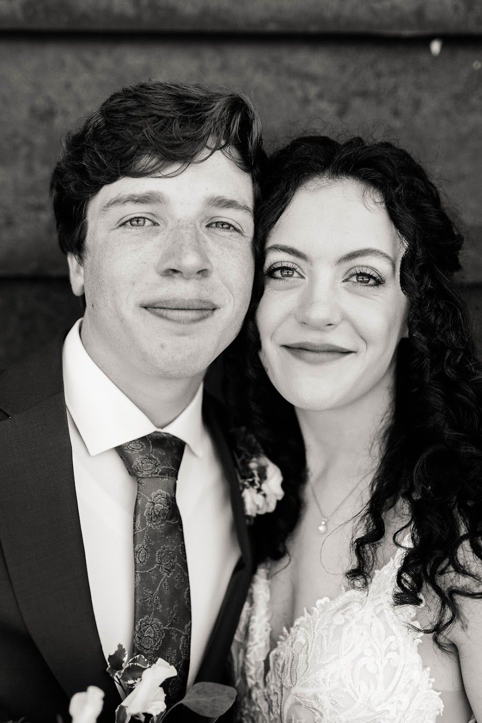 Black and white wedding portrait showing a happy couple in formal attire.