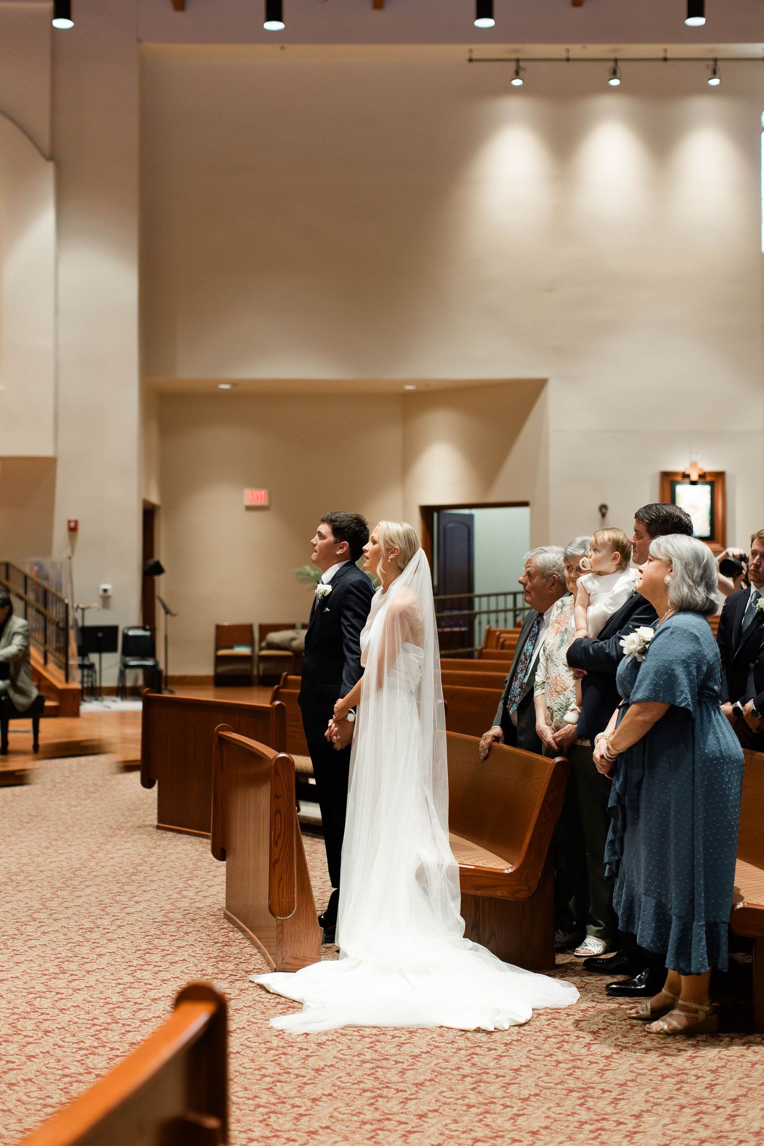 Wedding ceremony taking place in modern church sanctuary with carpeted floors.