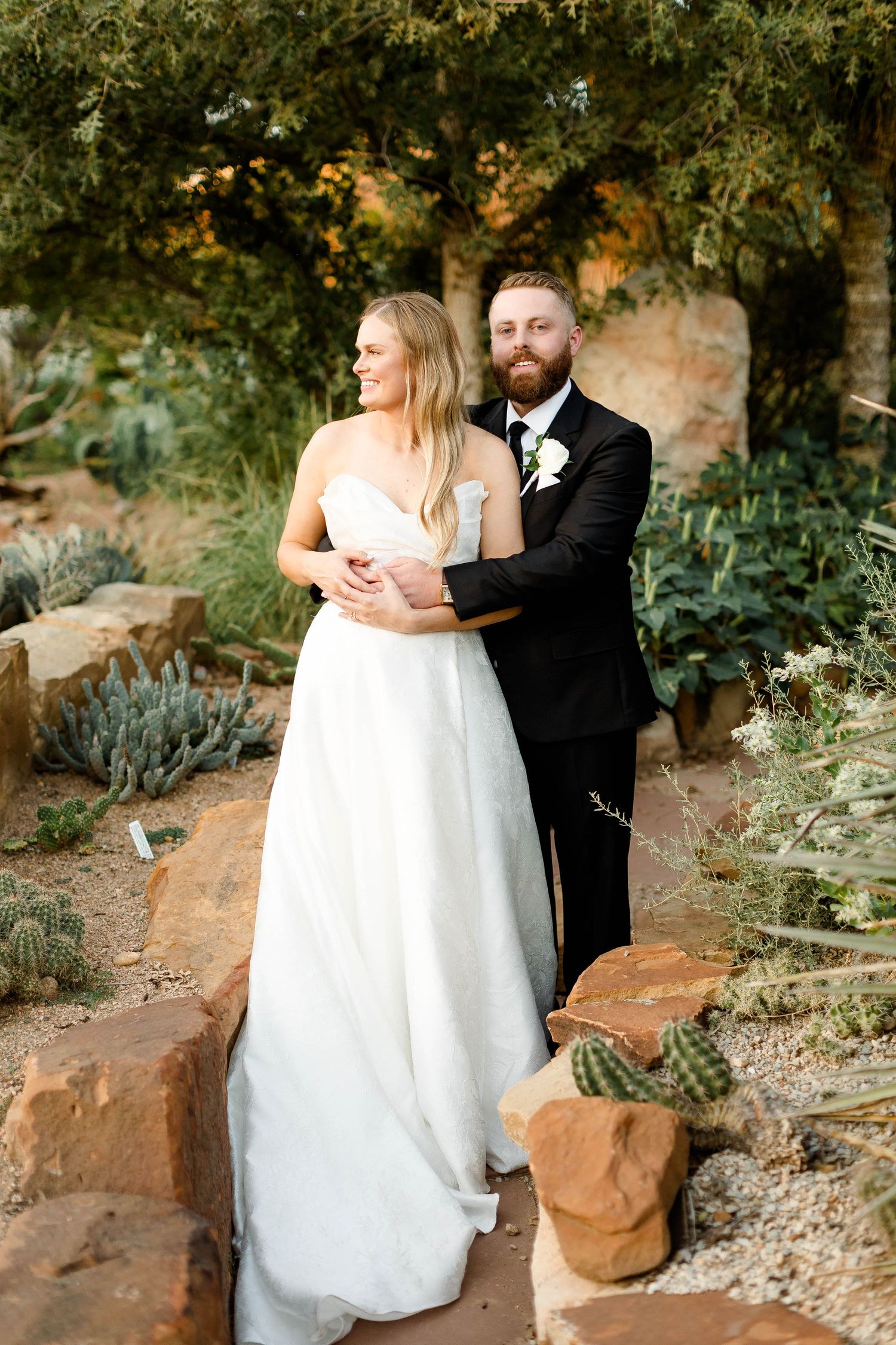 Romantic wedding portraits captured in a desert botanical garden with natural stone features.