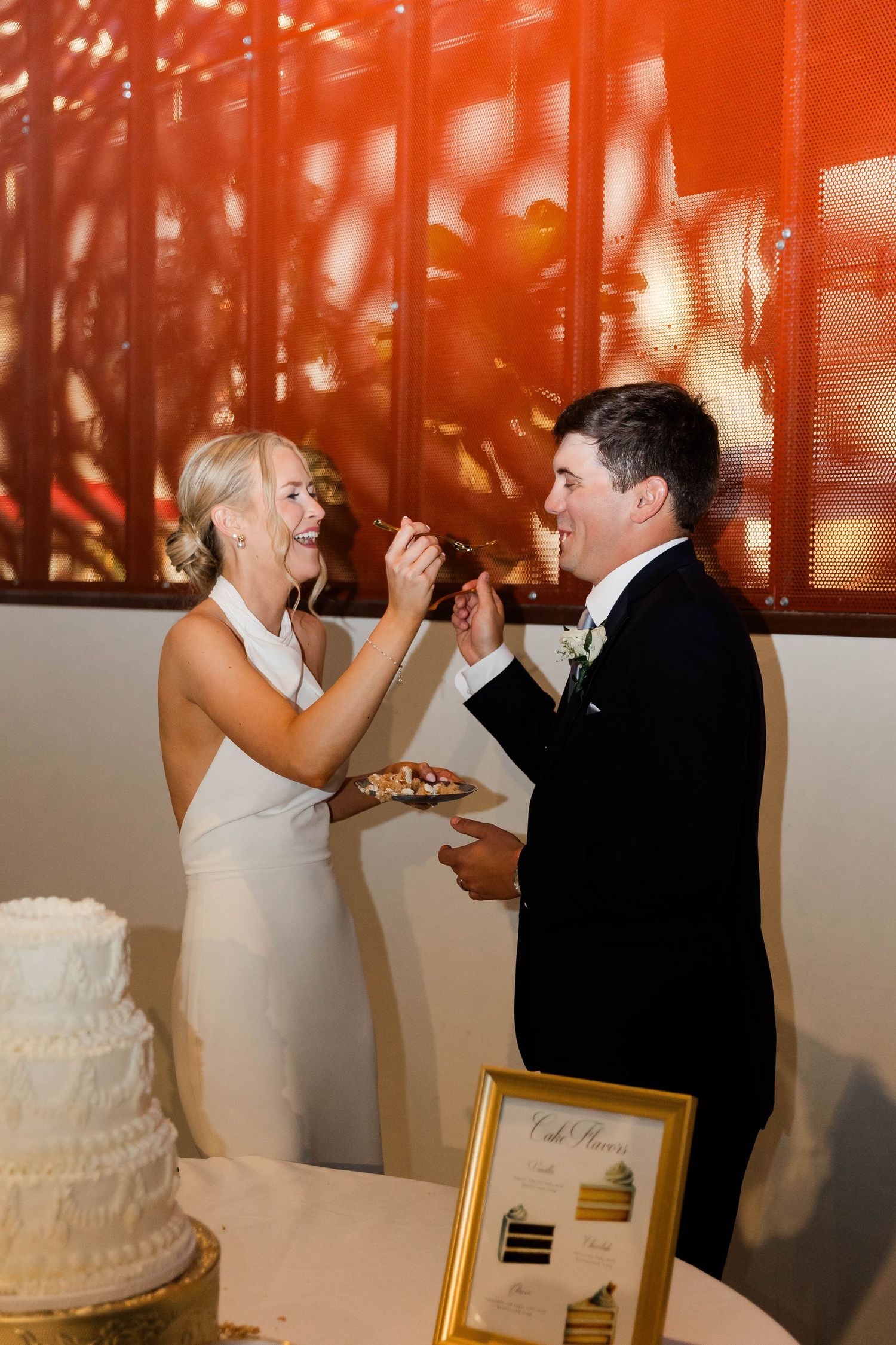 Bride and groom feed each other wedding cake during their traditional cake cutting ceremony.