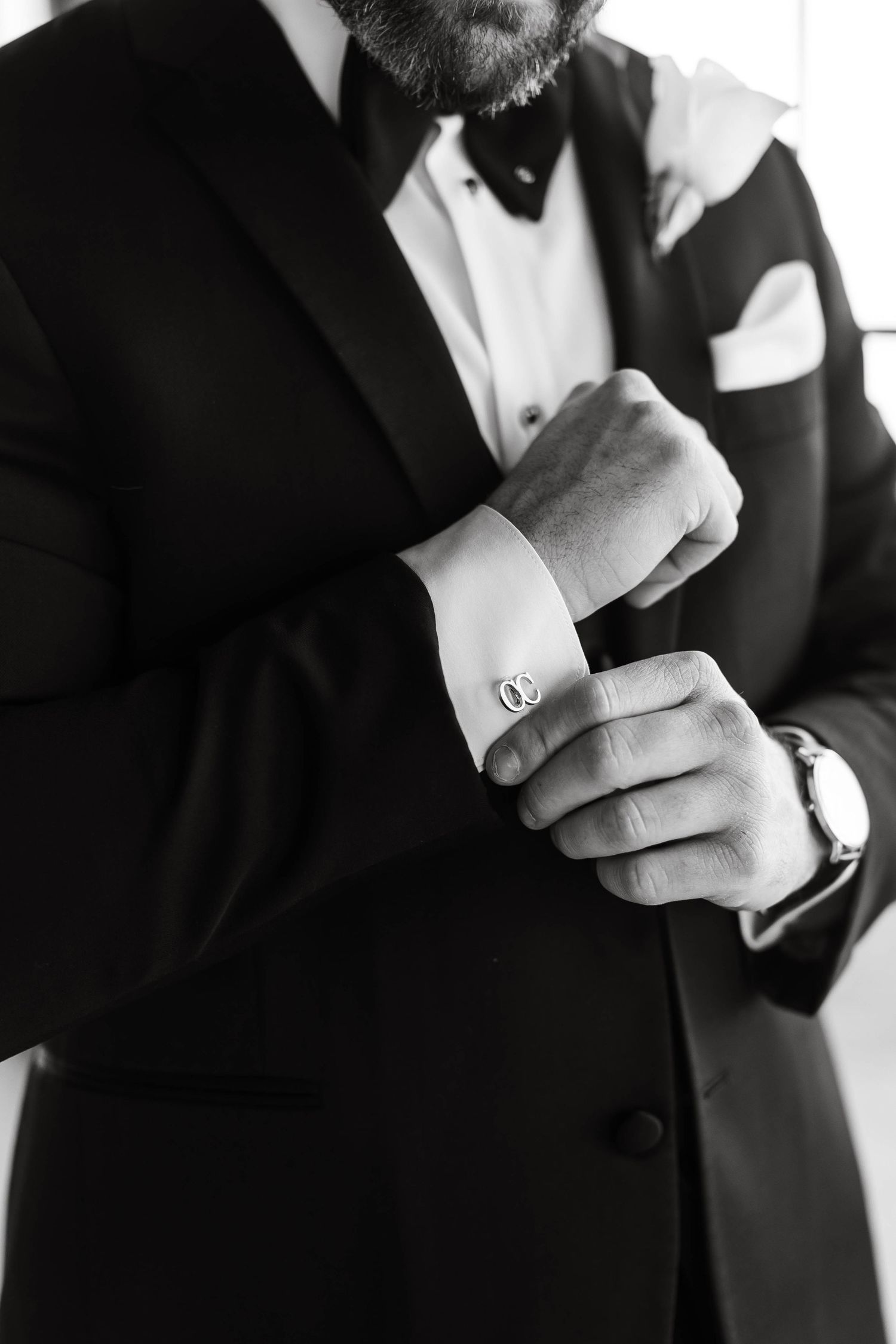 Close-up shots of groom adjusting his formal black tuxedo cufflinks.