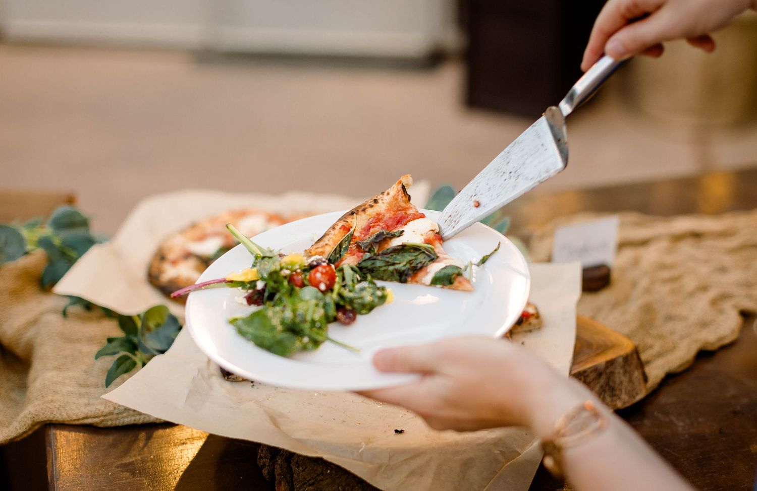 Elegant place settings and dining details arranged on a wooden table at an outdoor event.