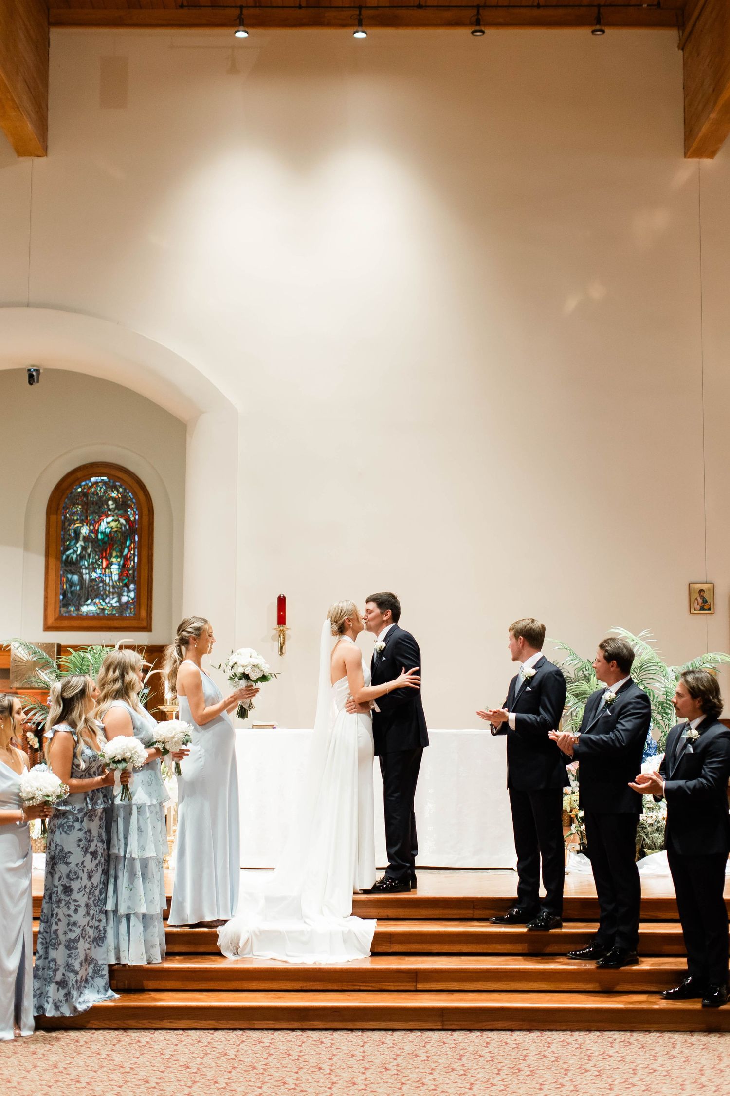 Wedding party lined up in a church performing a choreographed dance routine during the ceremony.