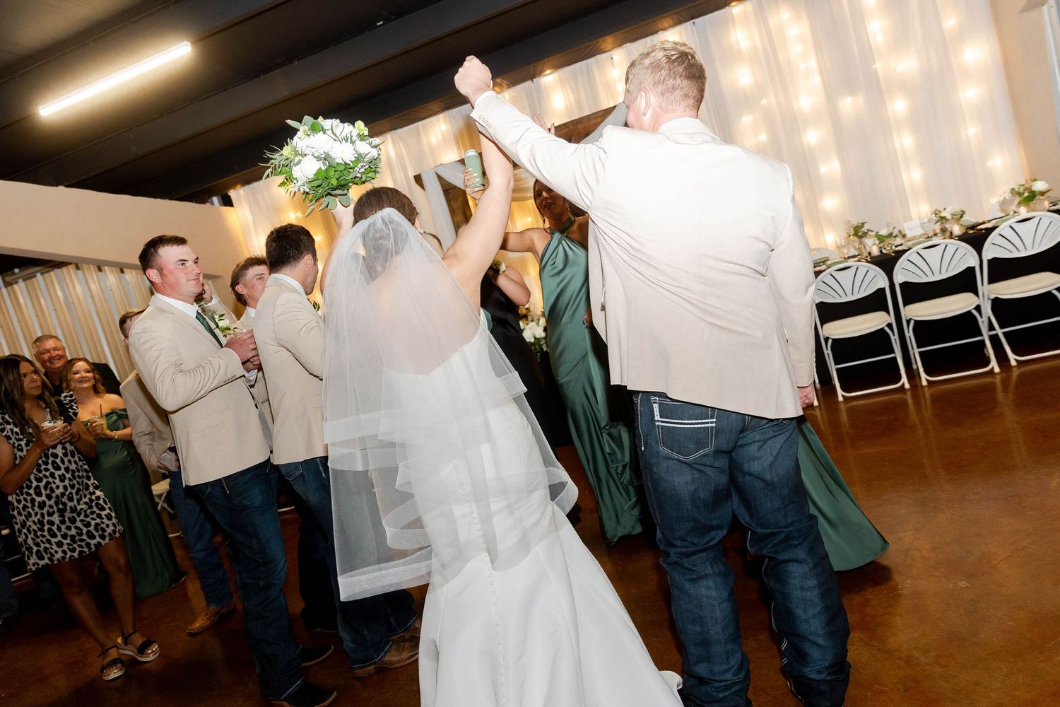 Wedding reception dance floor scene with string lights and casual atmosphere.