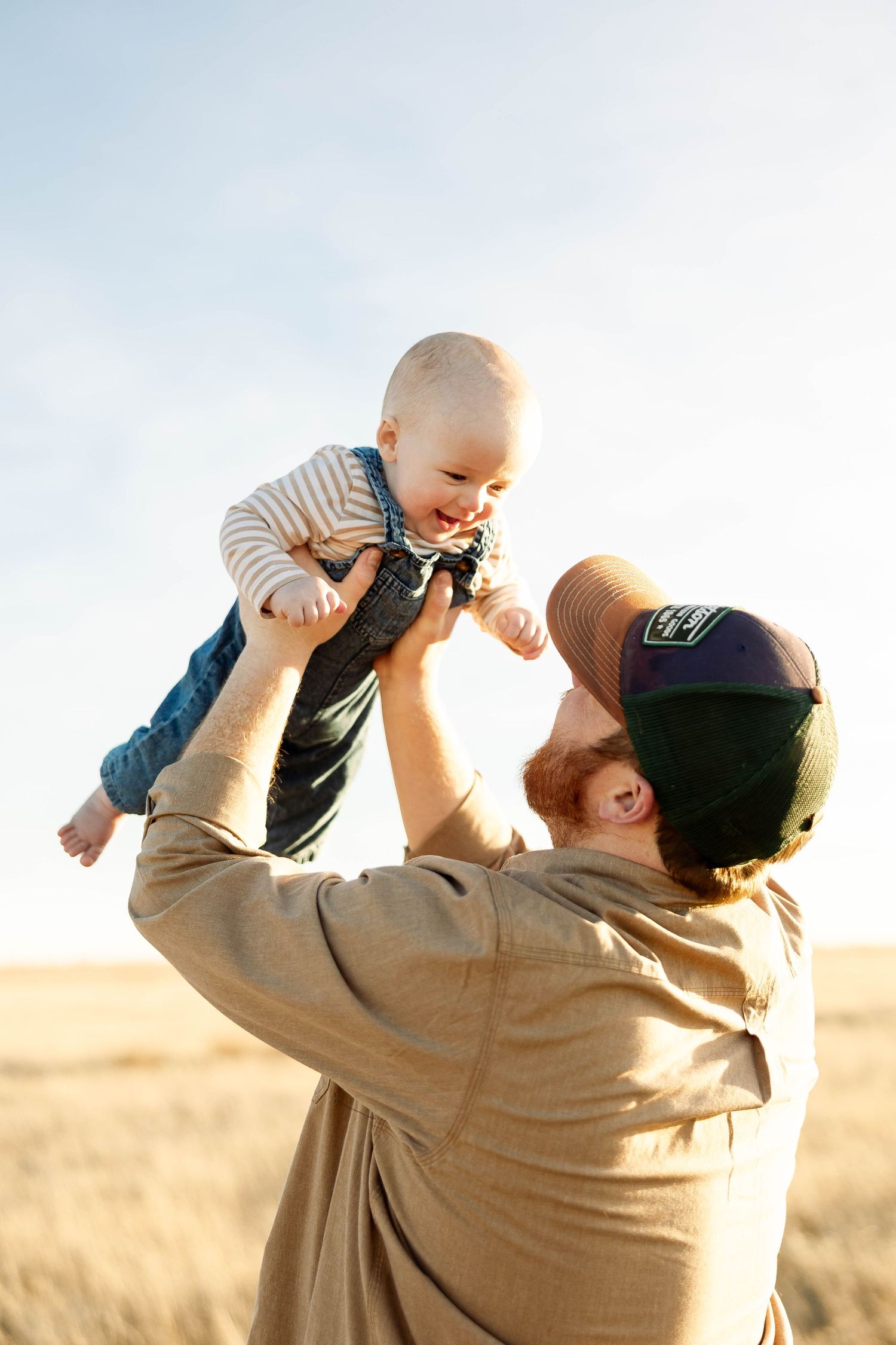 A sequence of joyful moments captured between an adult and baby playing together in a sunlit field at sunset.