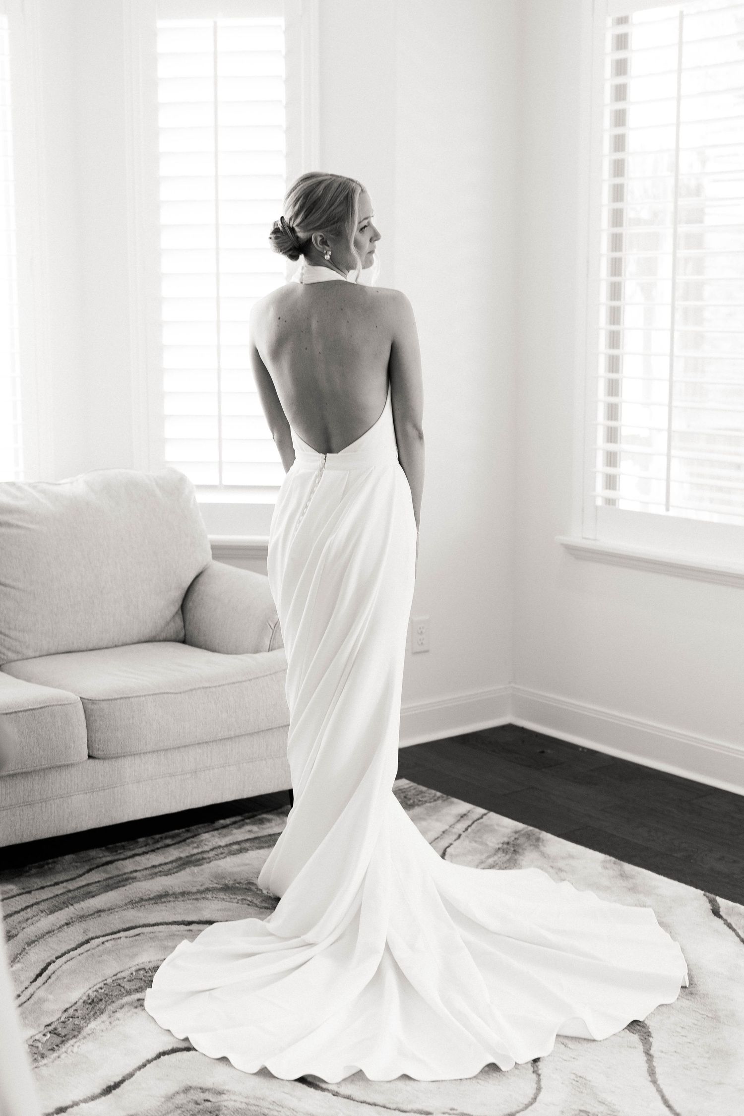 Elegant white wedding dress with train photographed from different angles in a bright modern room.