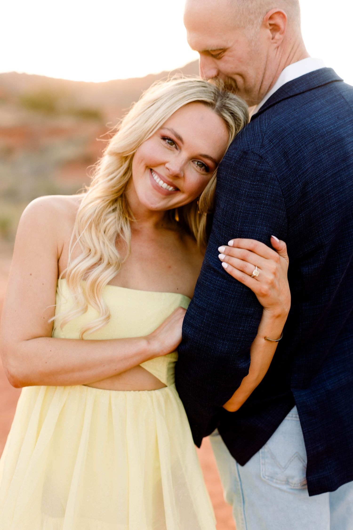 Intimate couple portraits in soft lighting with desert mountains in the background.