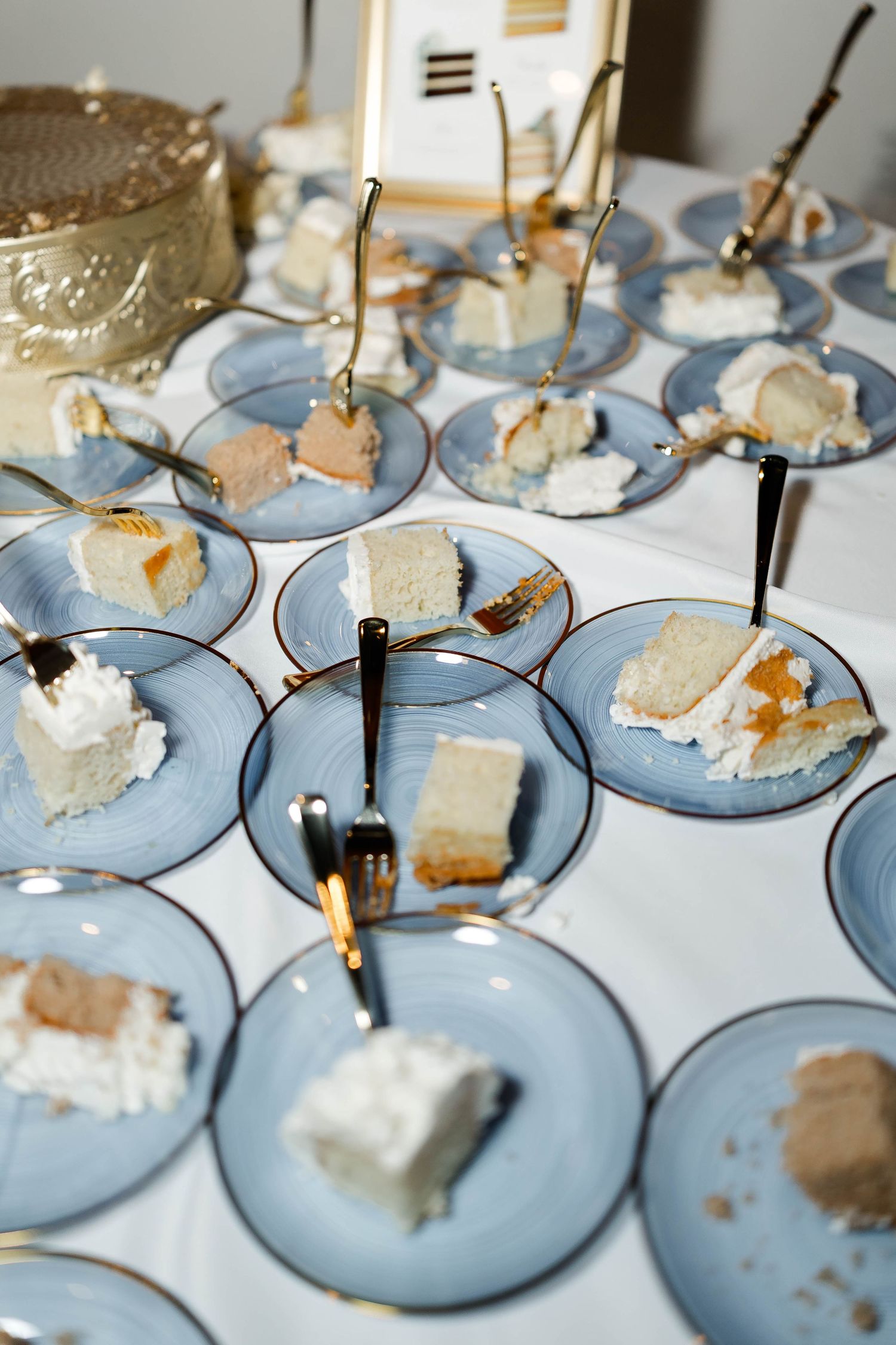Small plates of wedding cake samples arranged on light blue dessert plates for tasting.