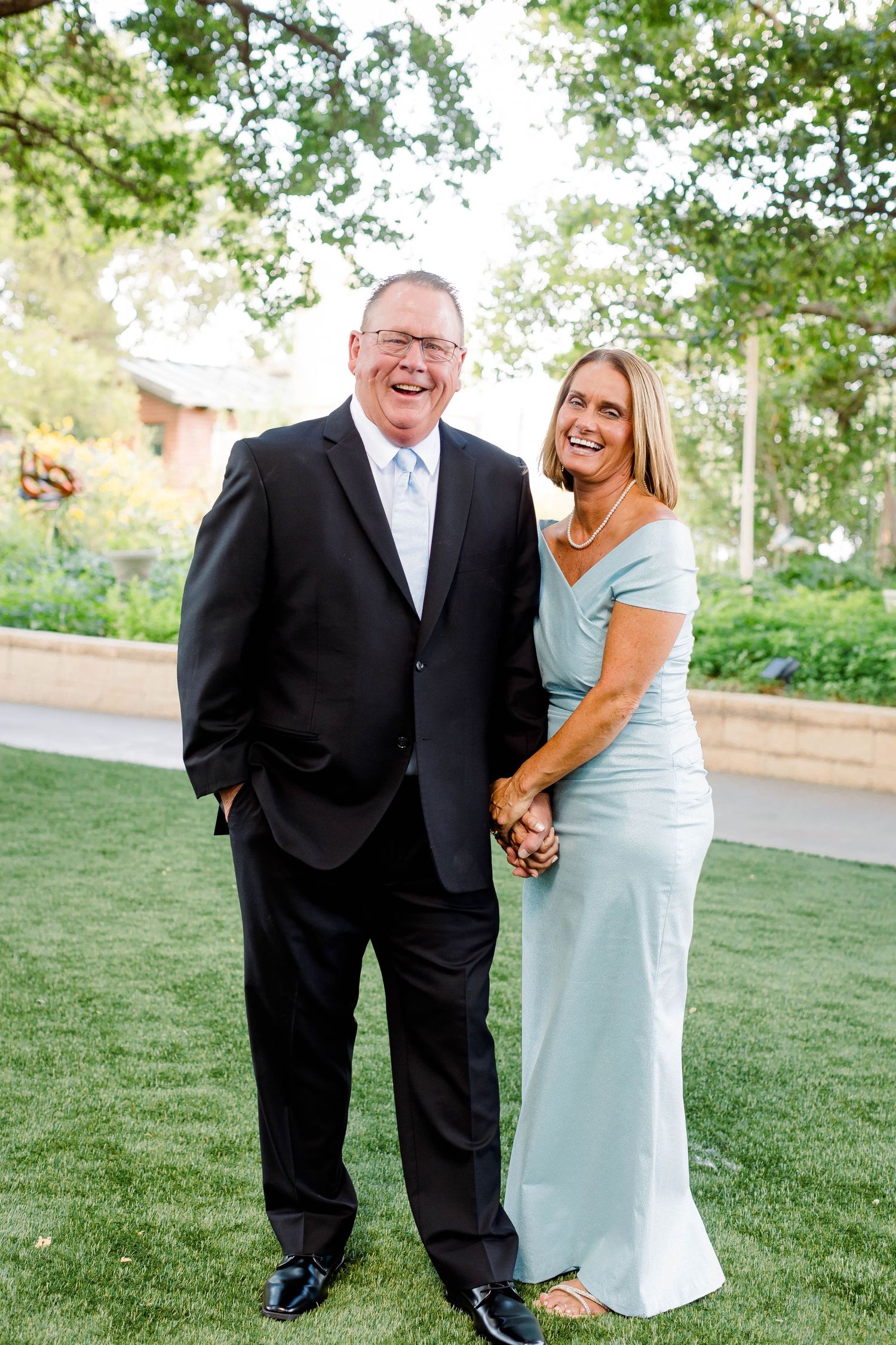 Candid wedding party portraits with joyful expressions in outdoor garden setting.