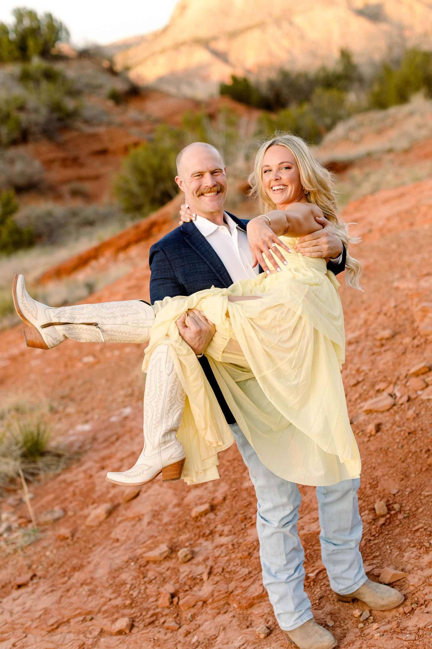 Romantic dance moves captured in a desert setting with warm lighting and red rock formations.