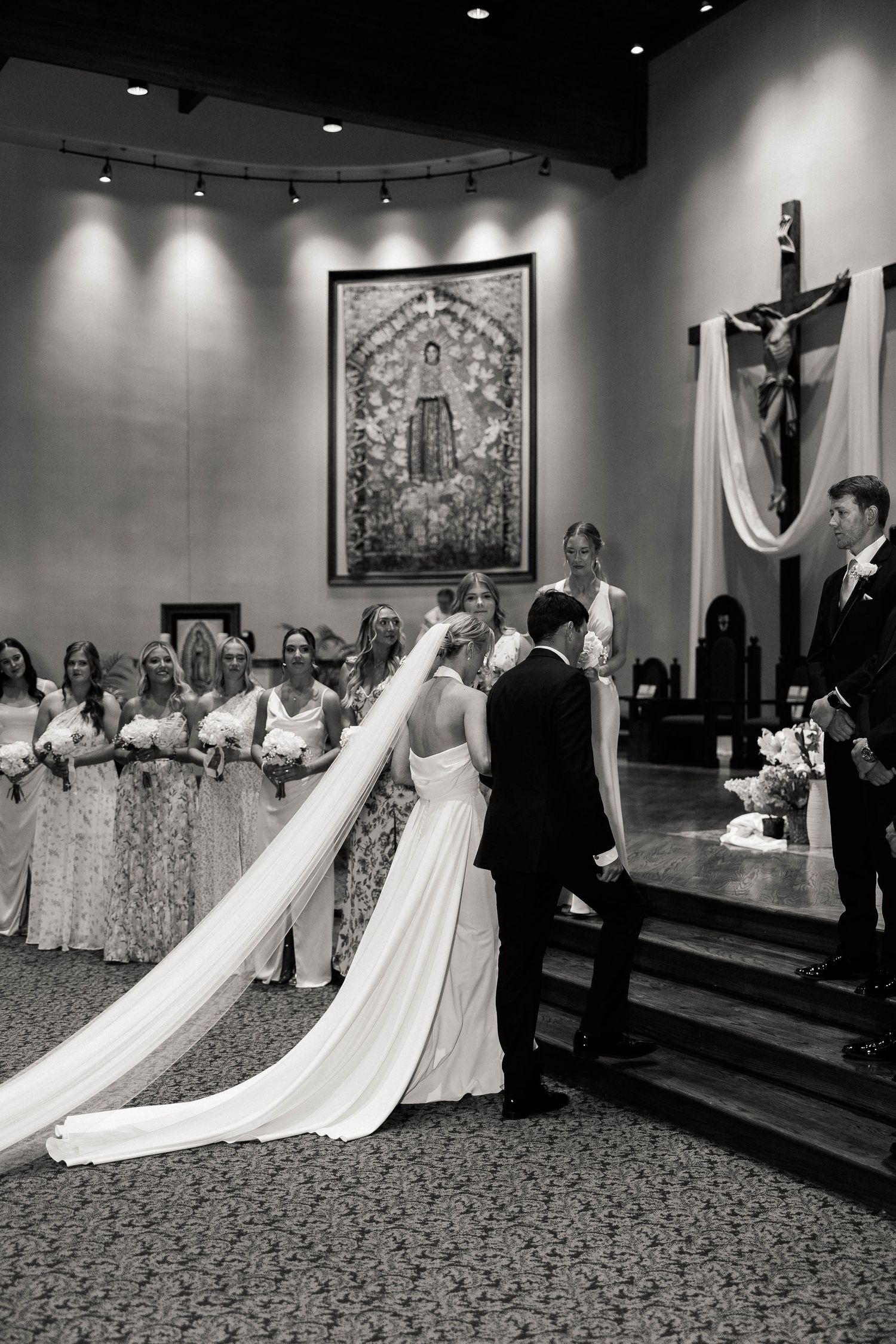 A wedding ceremony in progress at an ornate church altar with religious artwork.