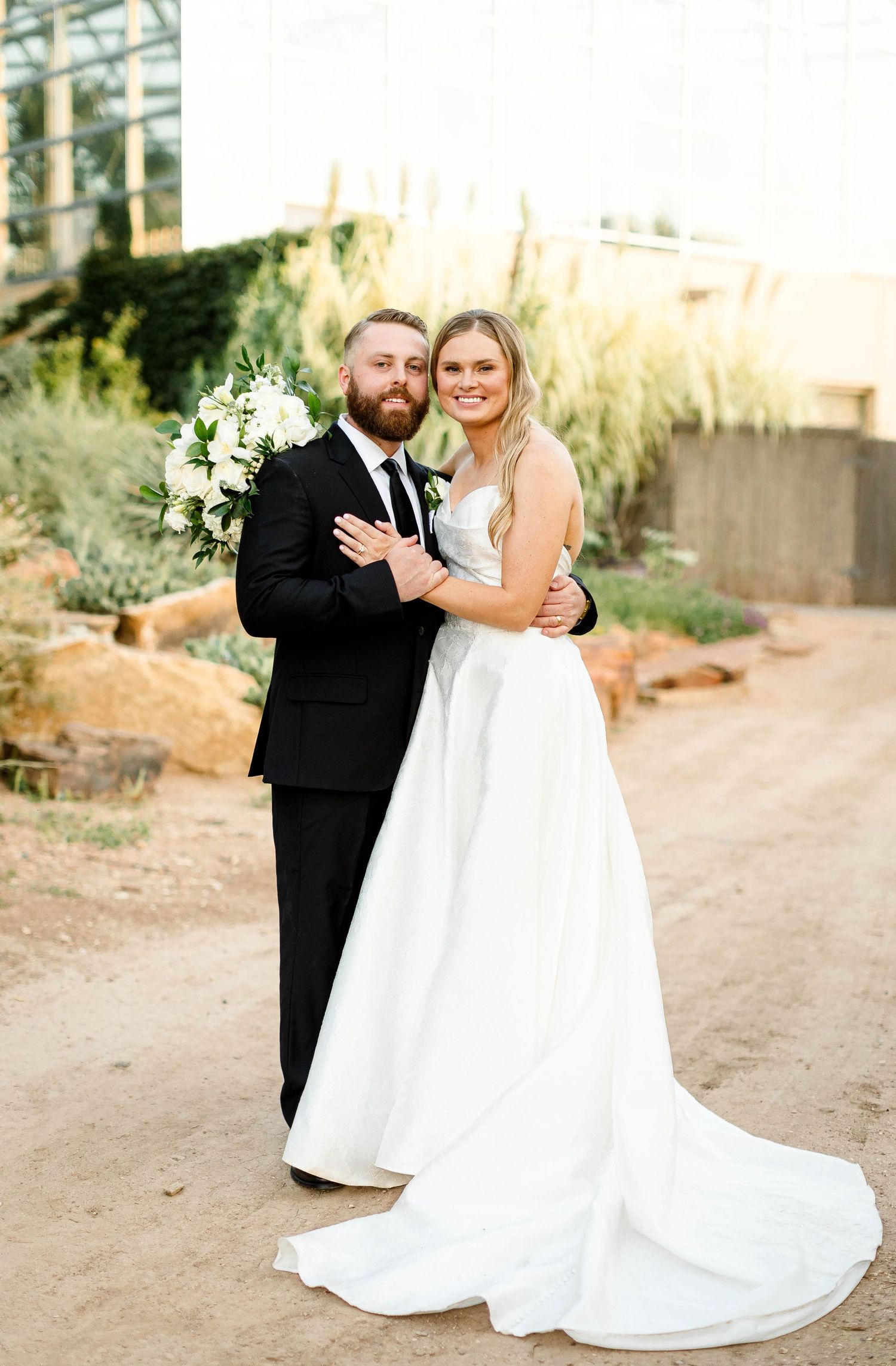 Wedding couple shares tender moments on a desert path during golden hour.