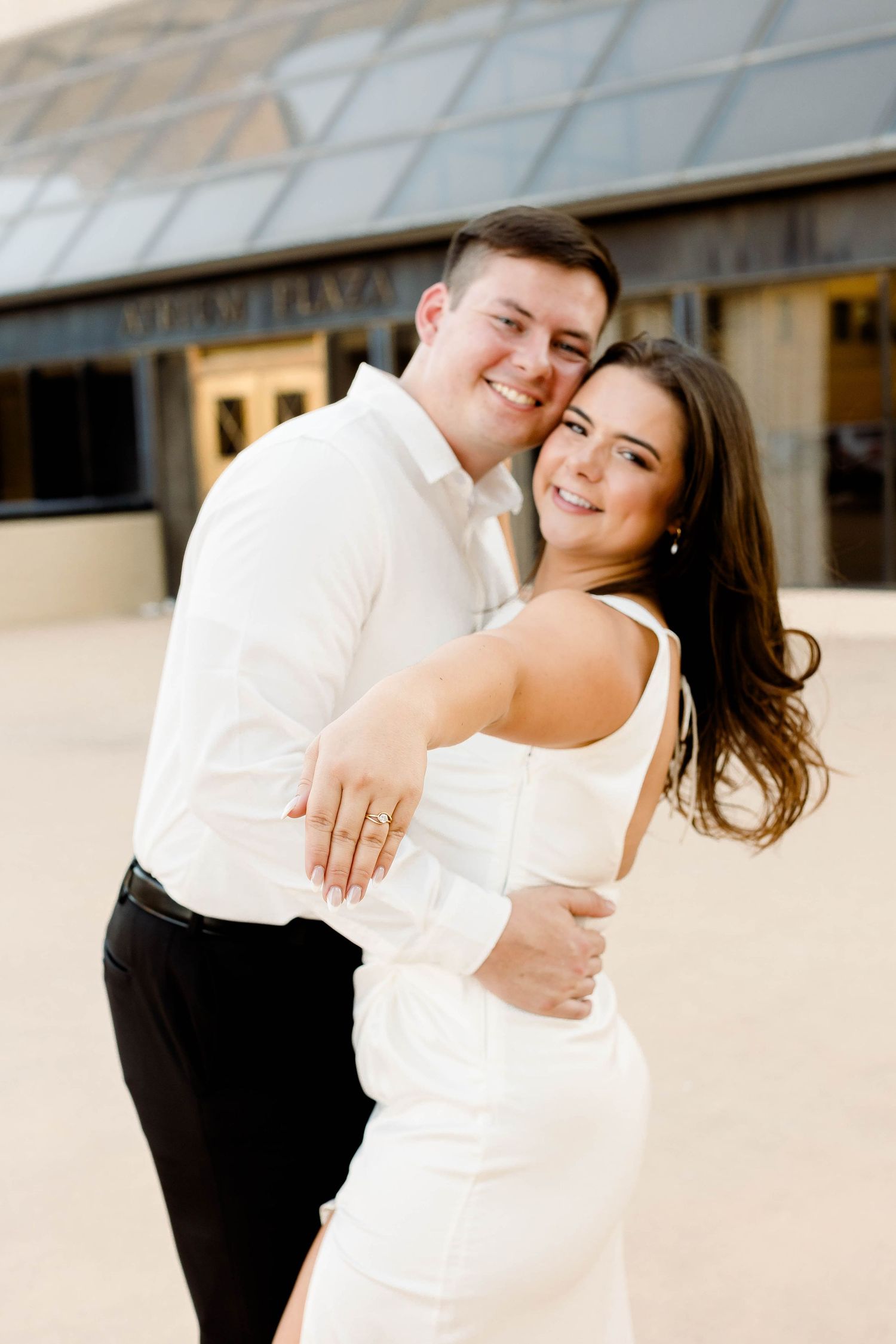 Joyful couple shares laughs and embraces during outdoor photo session.