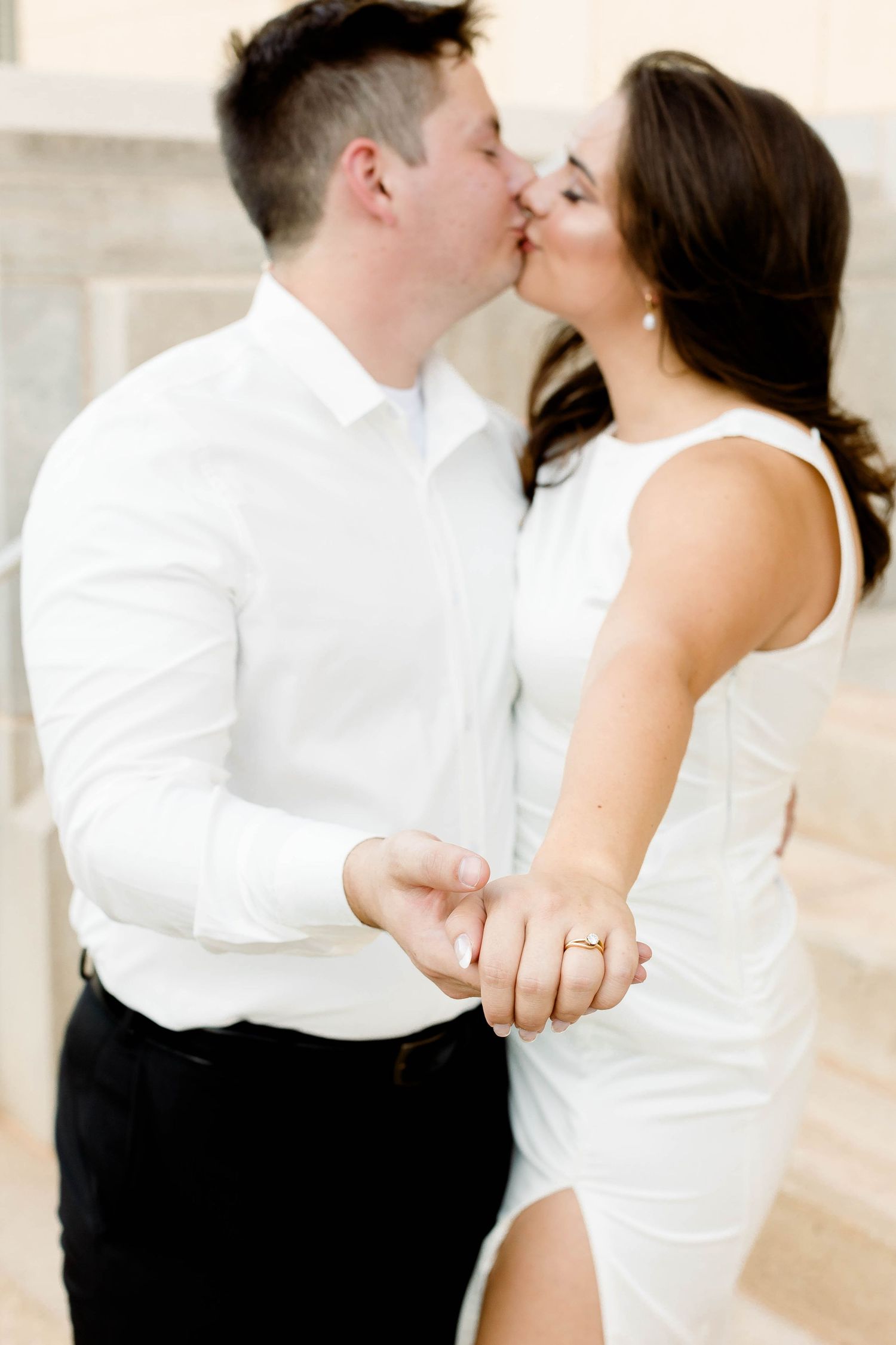 Close-up engagement photos showing tender moments between a couple in matching white outfits.