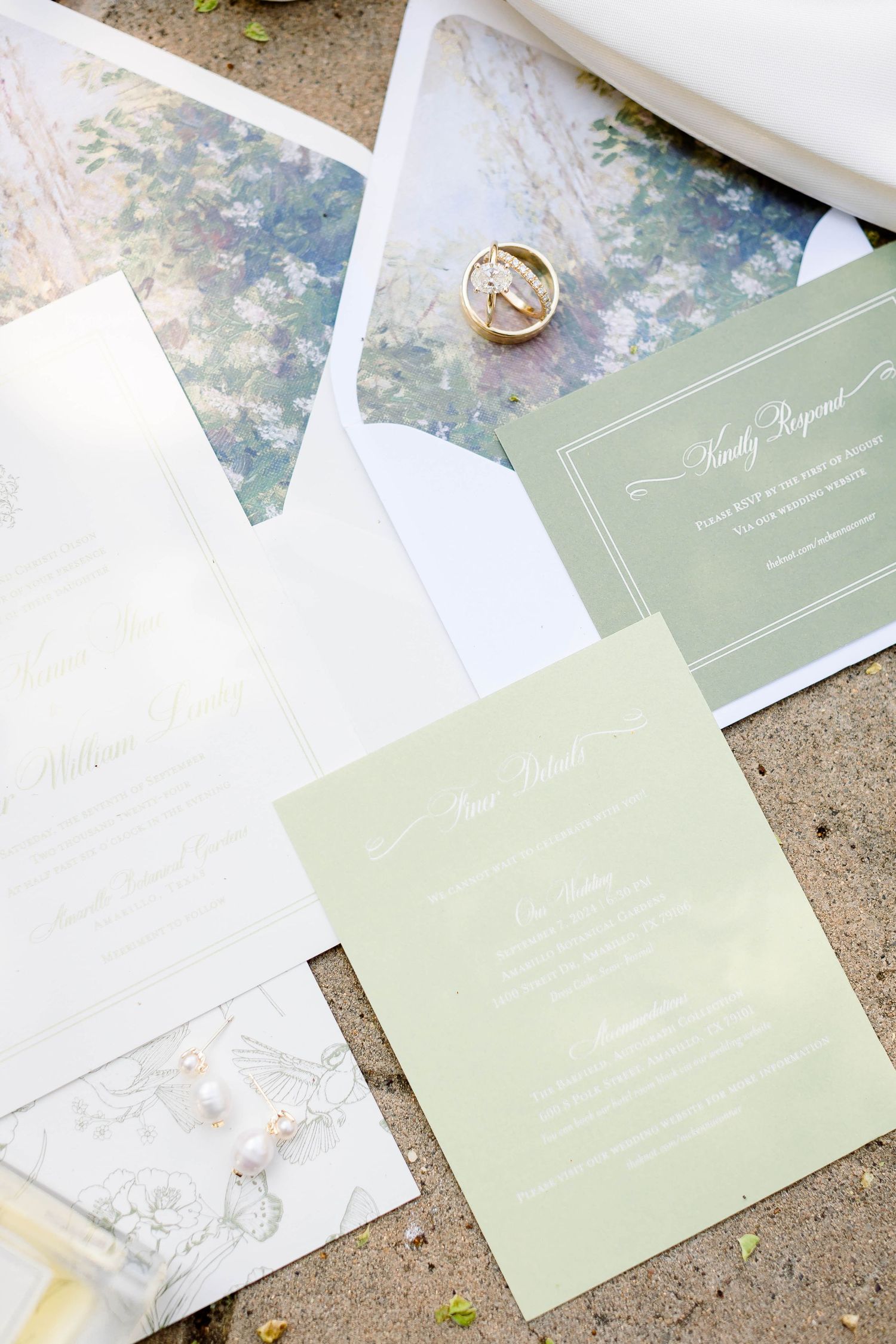 Wedding invitation suite featuring soft sage green and white paper with delicate designs.