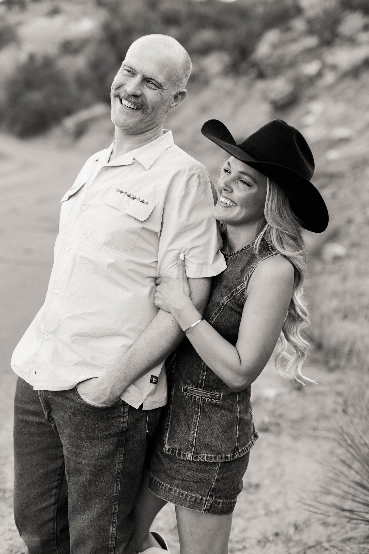 Black and white portrait of couple sharing intimate moments during outdoor photoshoot.