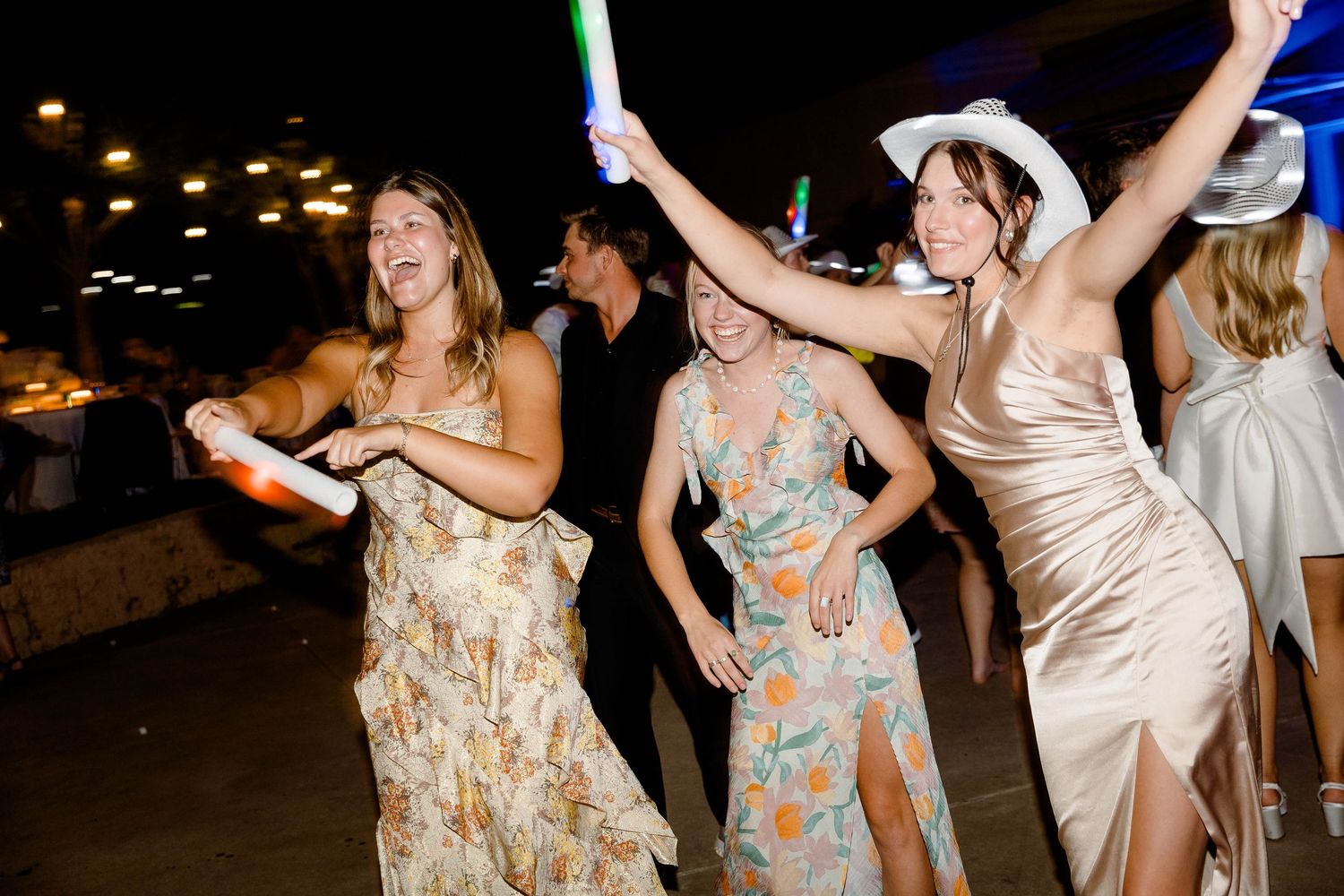 Wedding guests dancing and celebrating at an outdoor evening party.