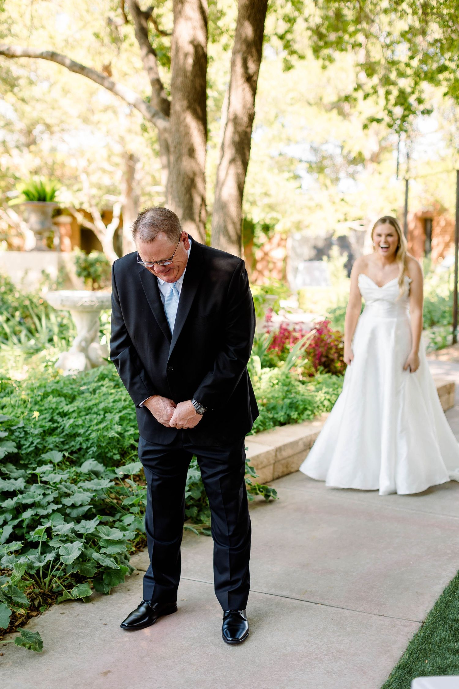 Emotional first look moment captured in a garden setting with natural lighting.