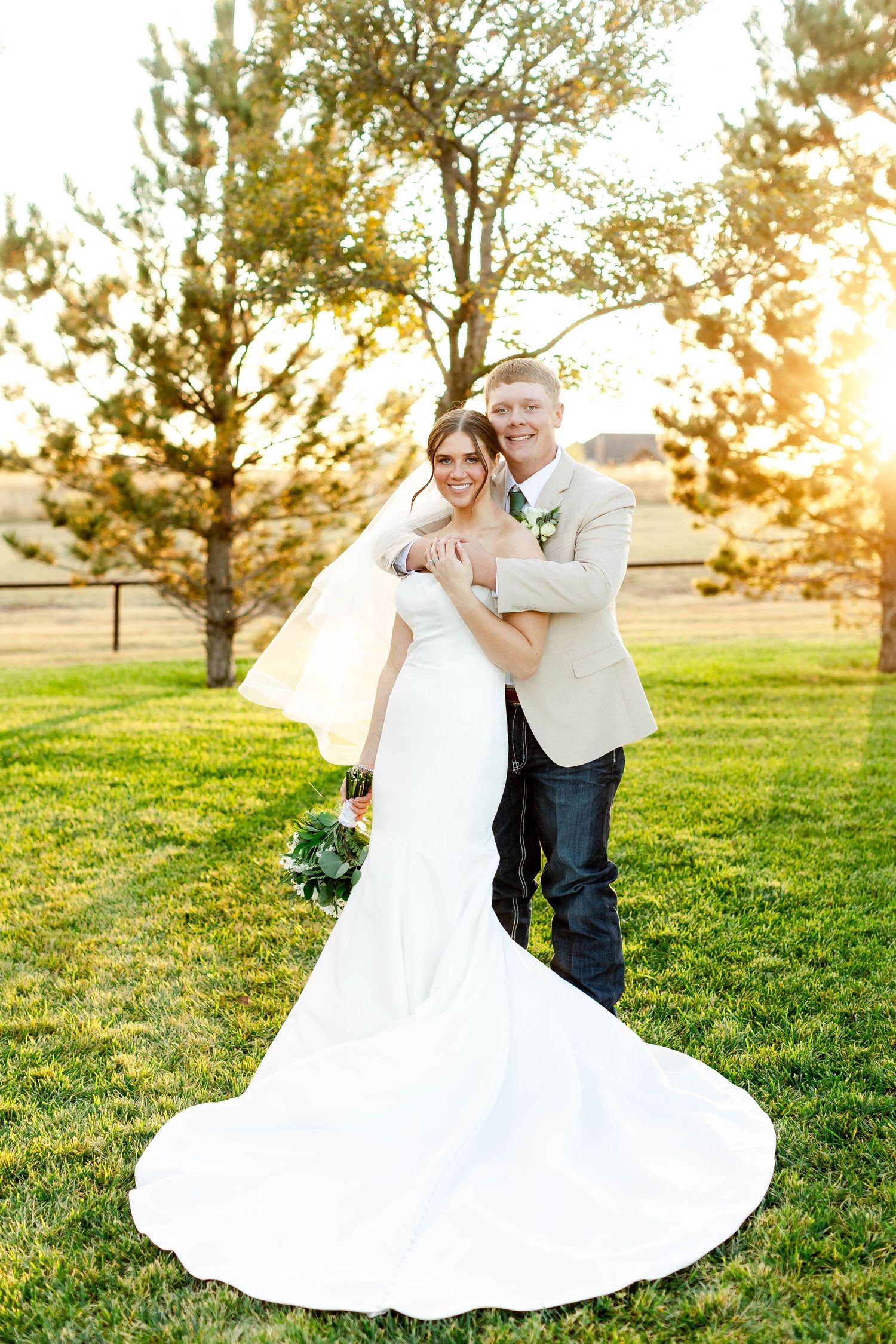 A romantic sunset photoshoot in a grassy field with a flowing white wedding dress creating elegant movement.