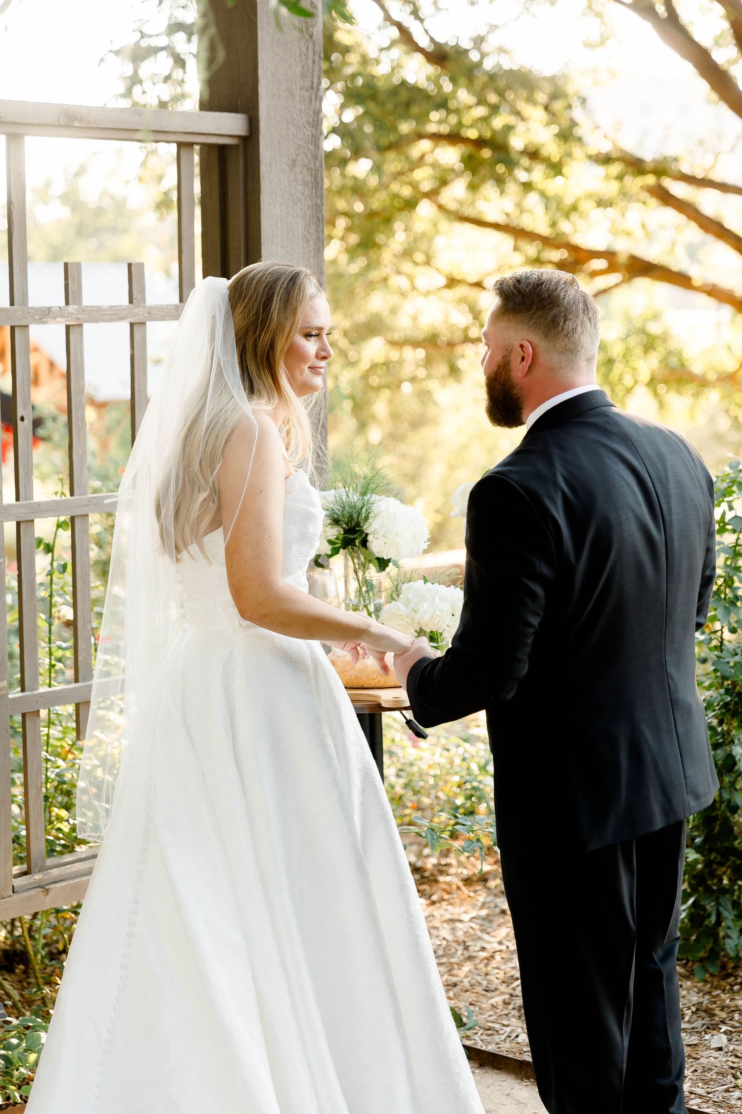 Candid wedding moment captured under a rustic pavilion with natural lighting.