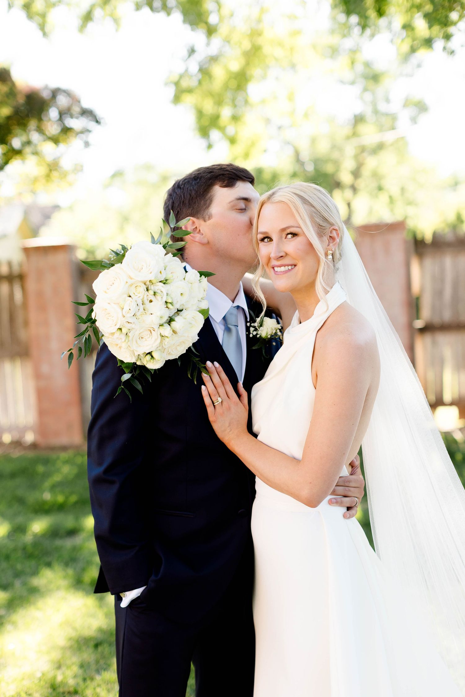 Romantic wedding portraits captured in a garden setting with natural lighting.